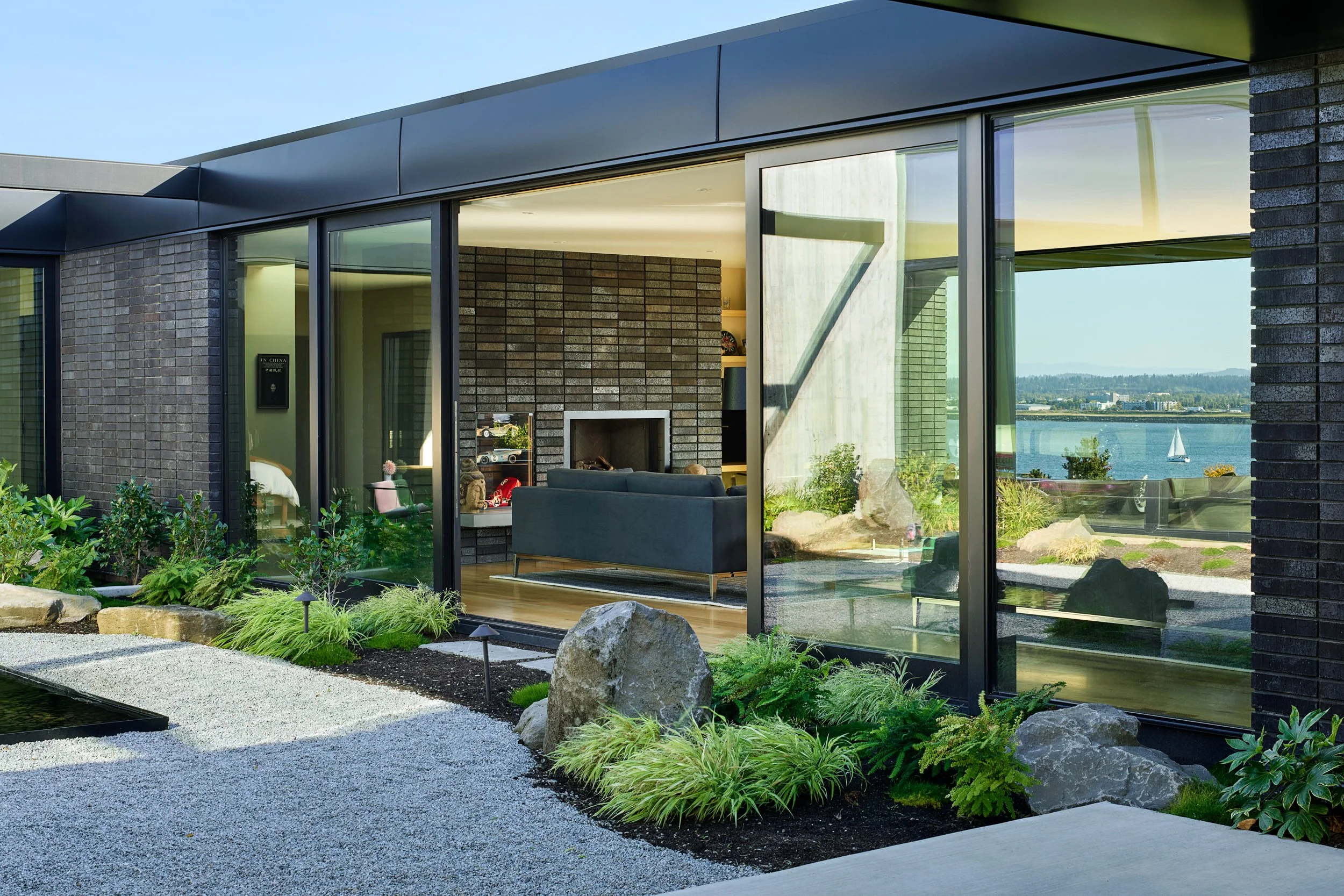 View of living room from courtyard with gravel pathway — William Kaven Architecture.