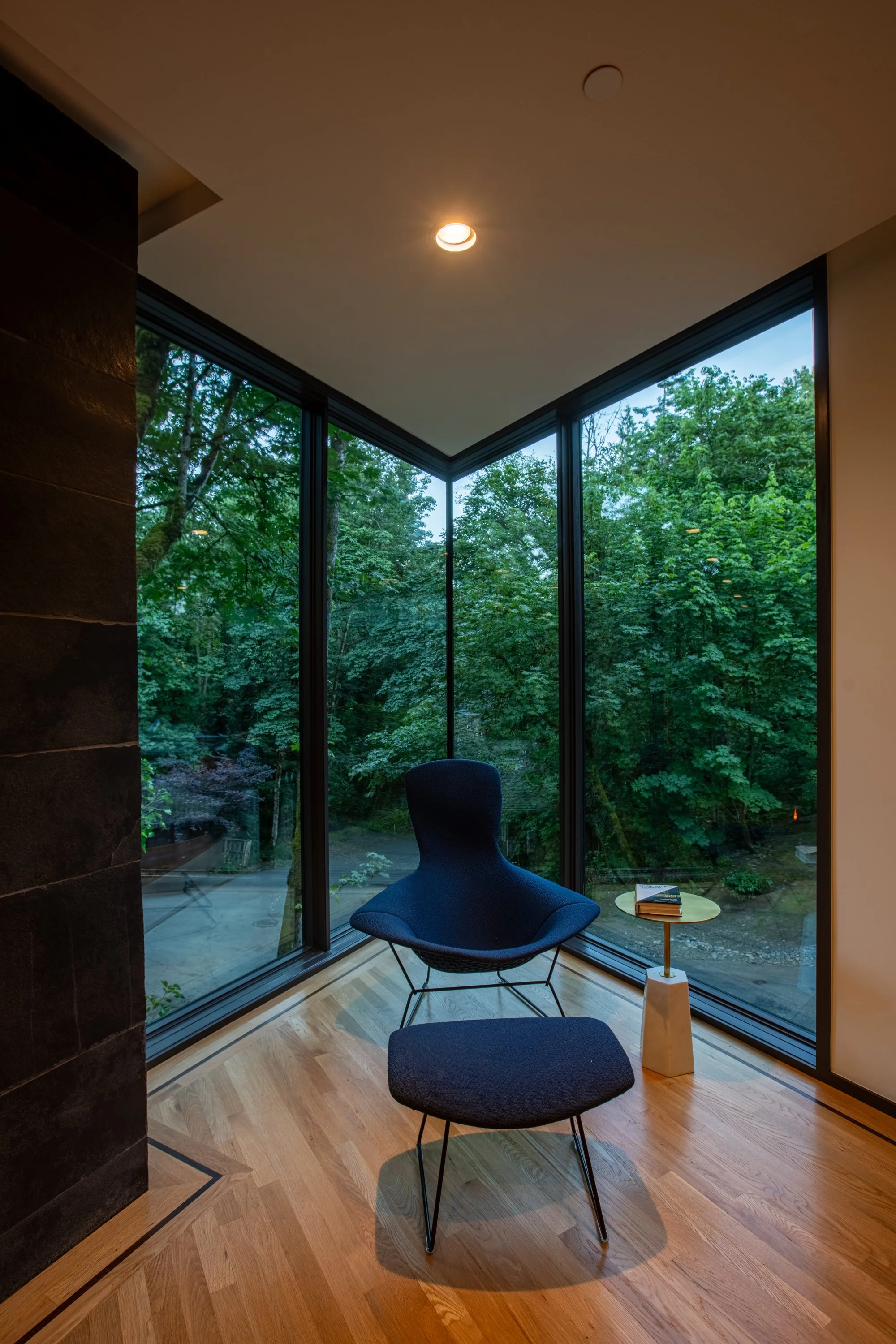 Reading chair and ottoman in corner of modern forest house — William Kaven Architecture