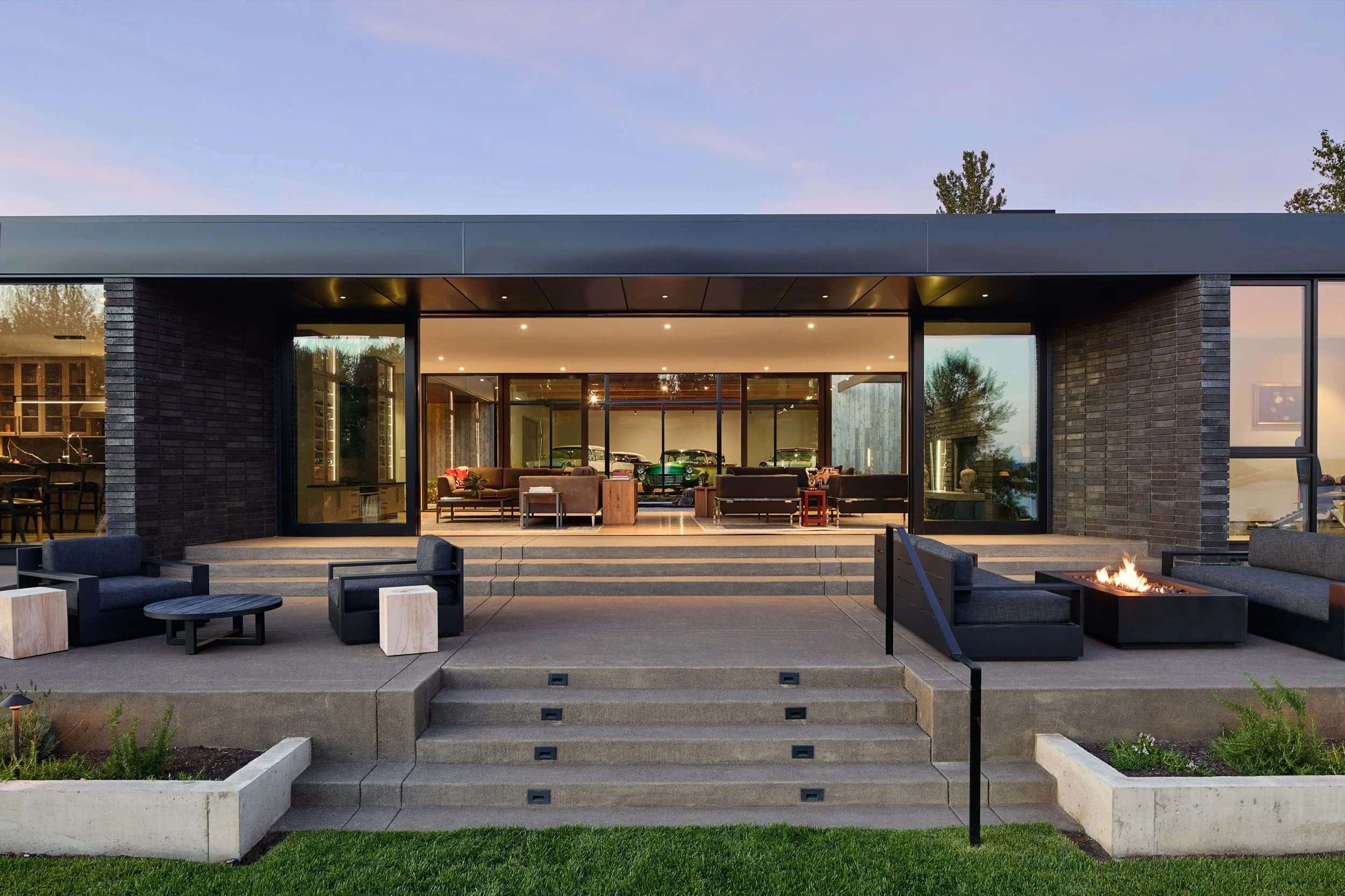Back terrace of house with fire pit and view of living room — William Kaven Architecture