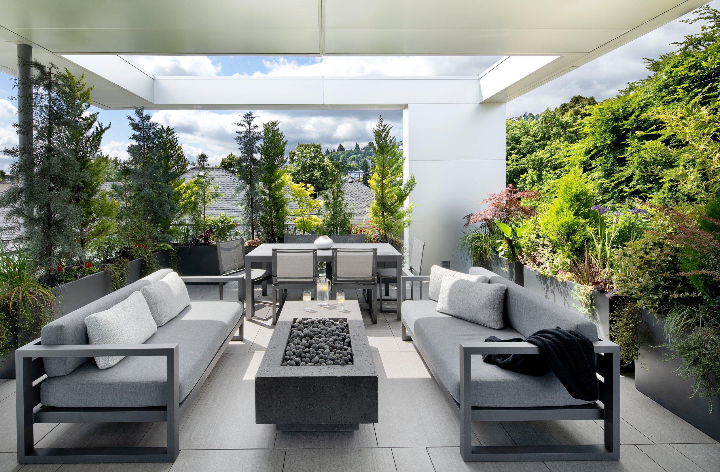 Rooftop terrace with fire table, seating, and dining area — William Kaven Architecture