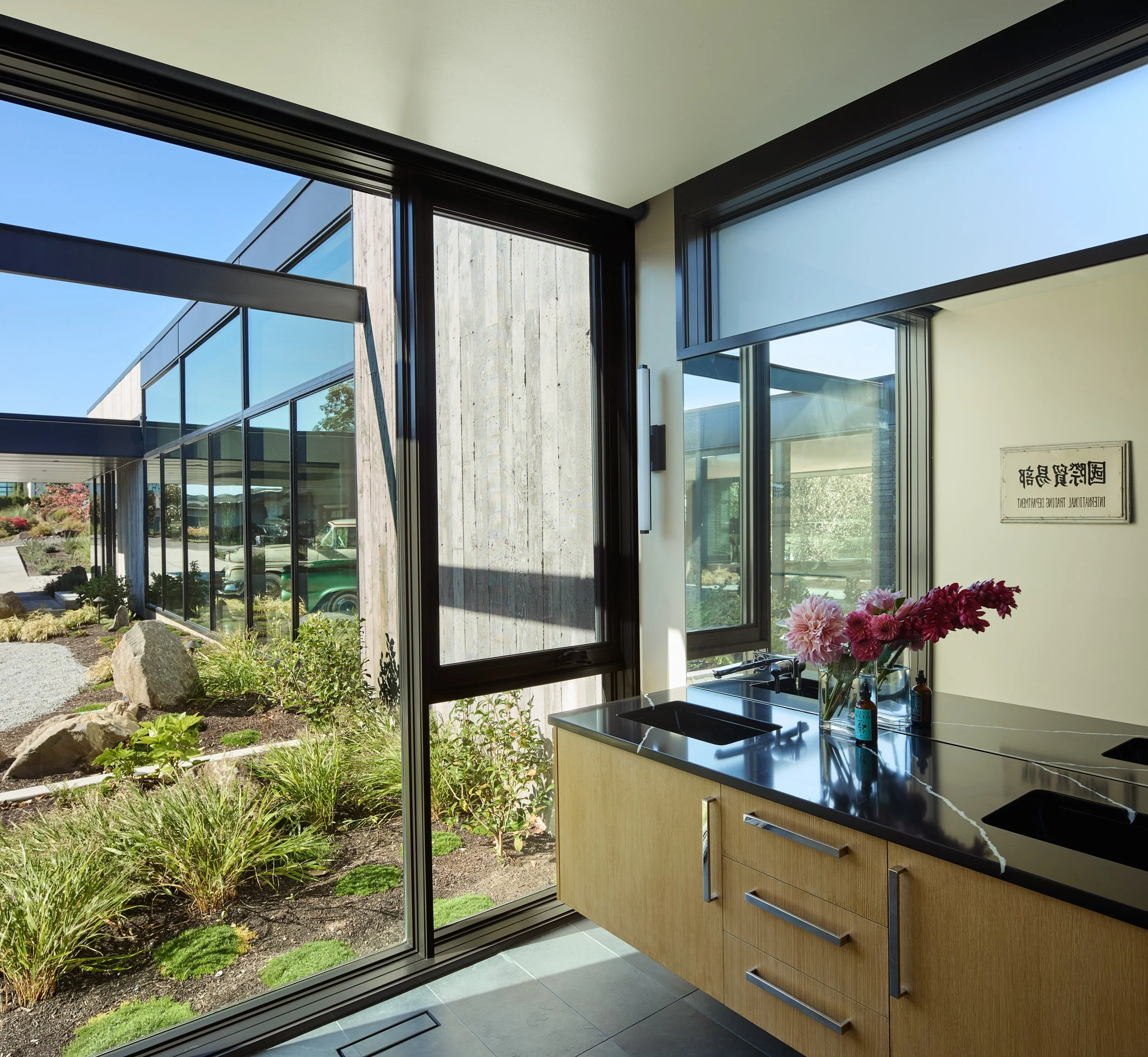 Modern bathroom with flowers and view of courtyard — William Kaven Architecture.