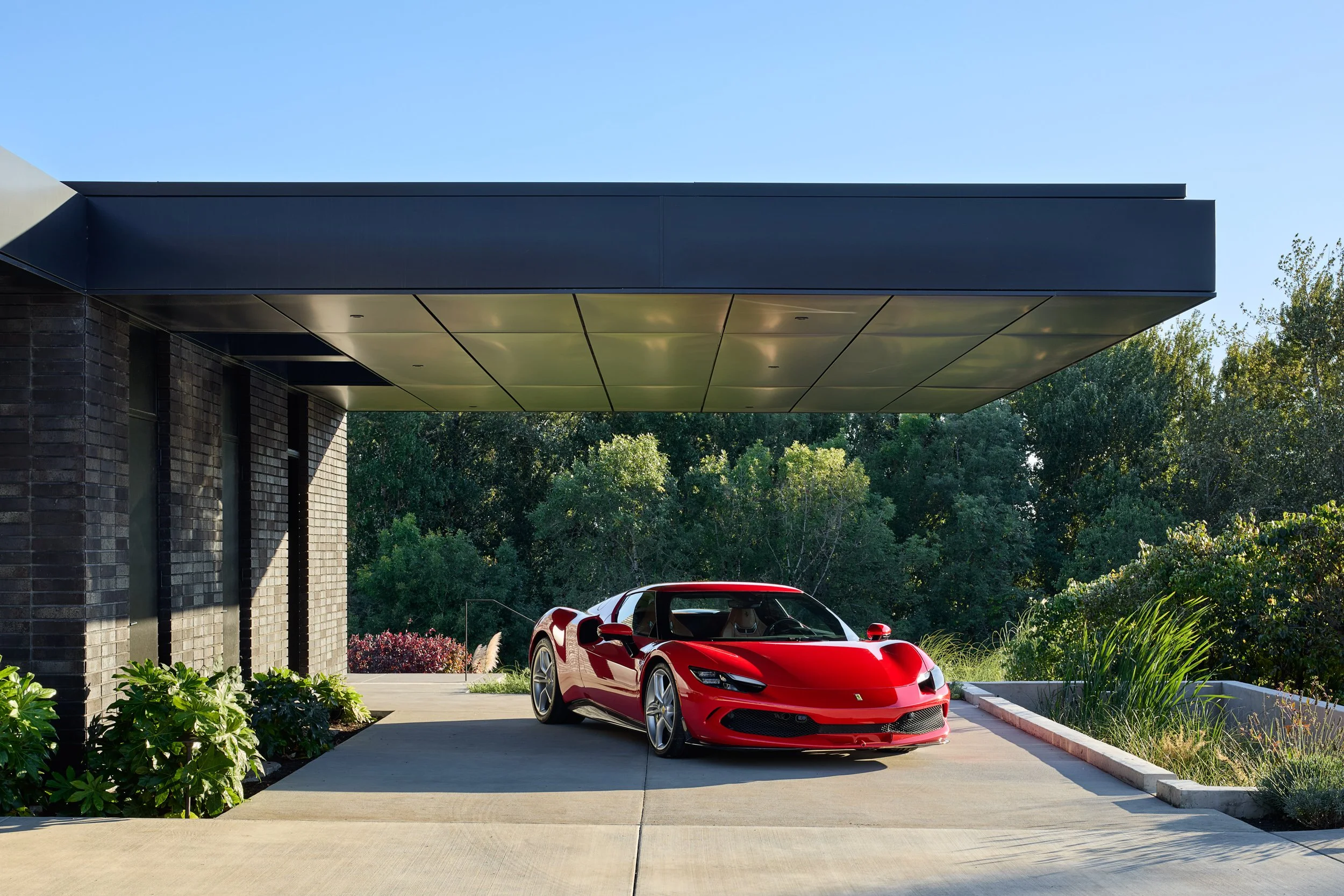 Red Ferrari under carport at El Capitola Residence, designed by William Kaven Architecture