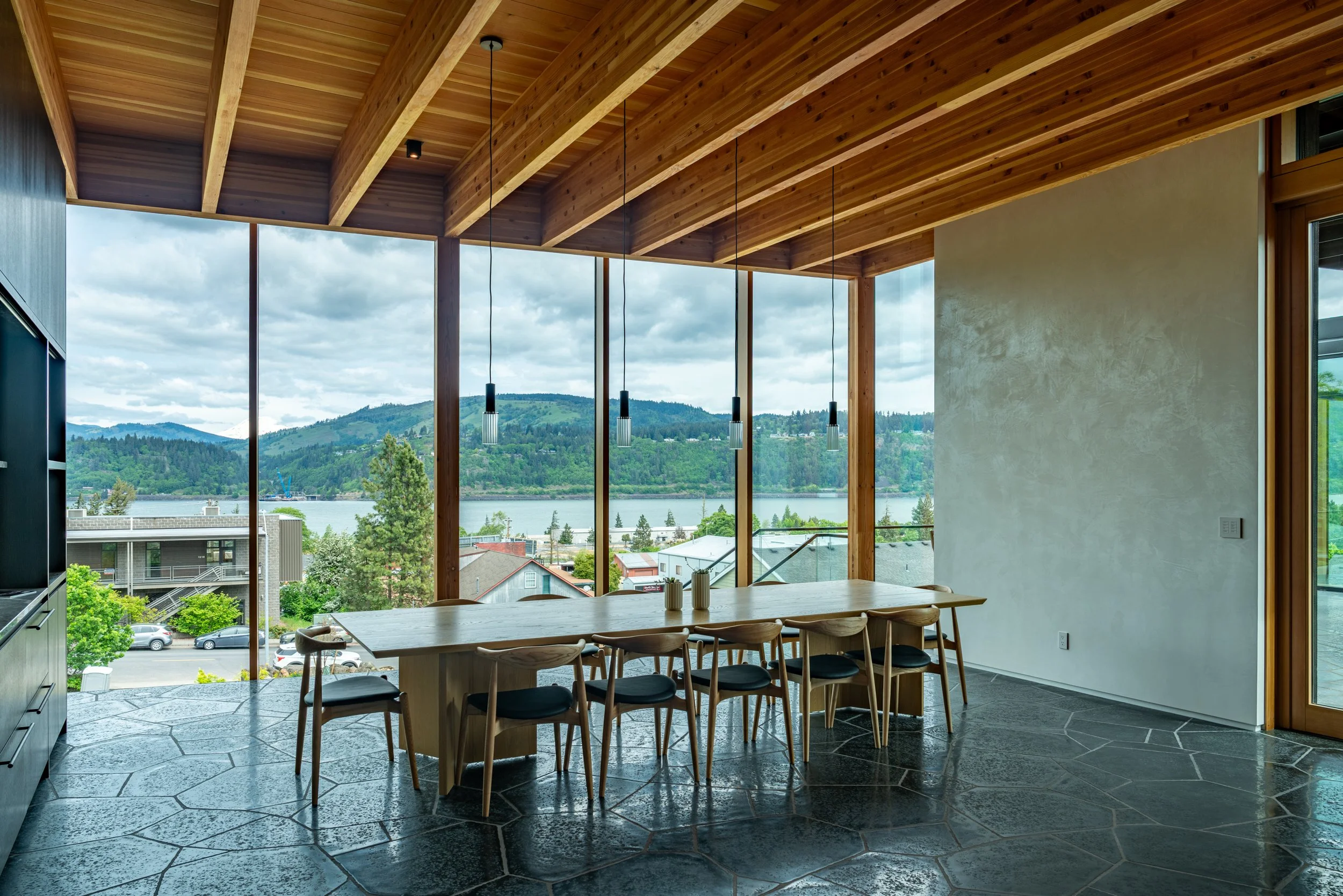 Dining room with view of Hood River, plaster walls, and basalt floors — William Kaven Architecture