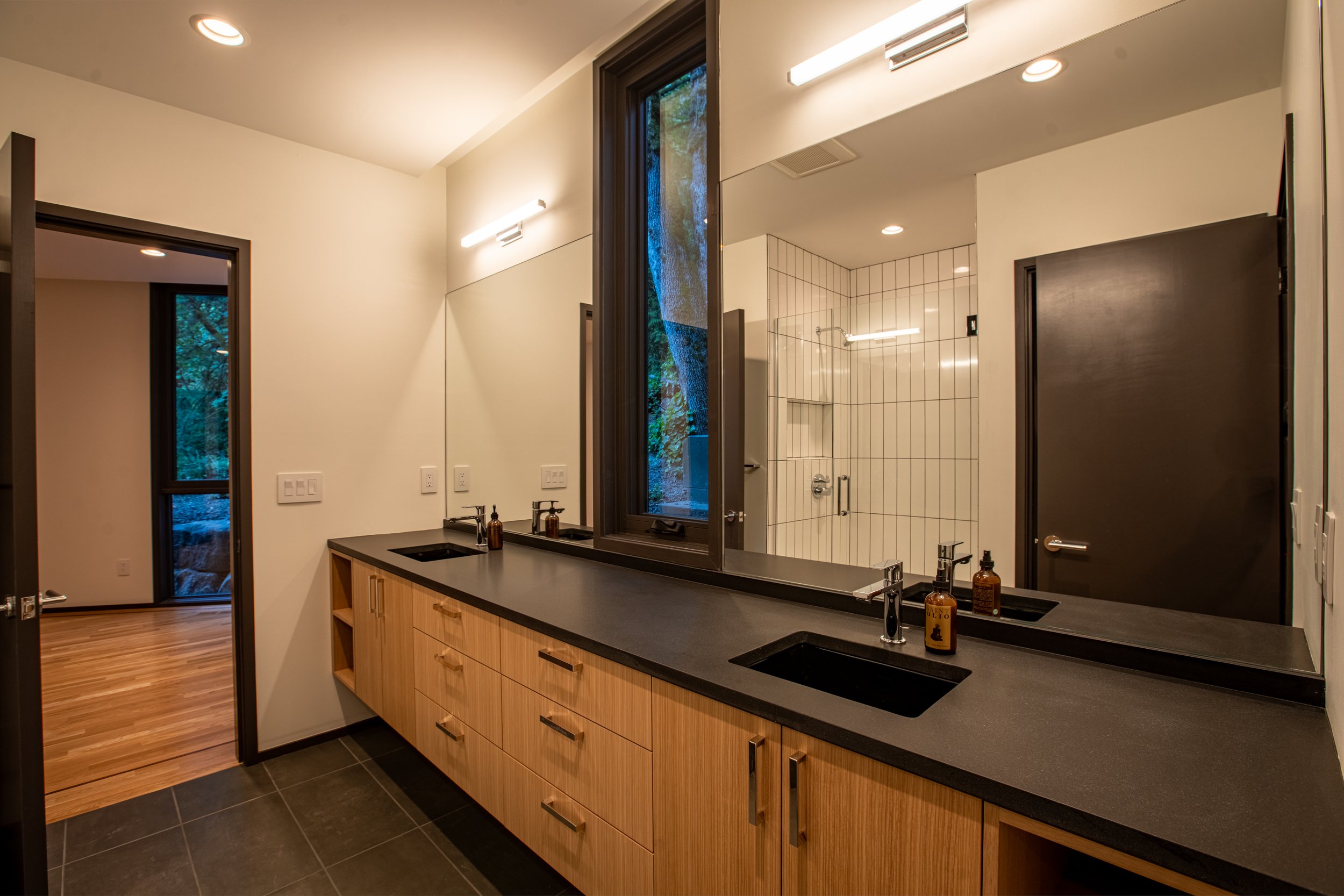 Modern bathroom with black slate countertops — William Kaven Architecture