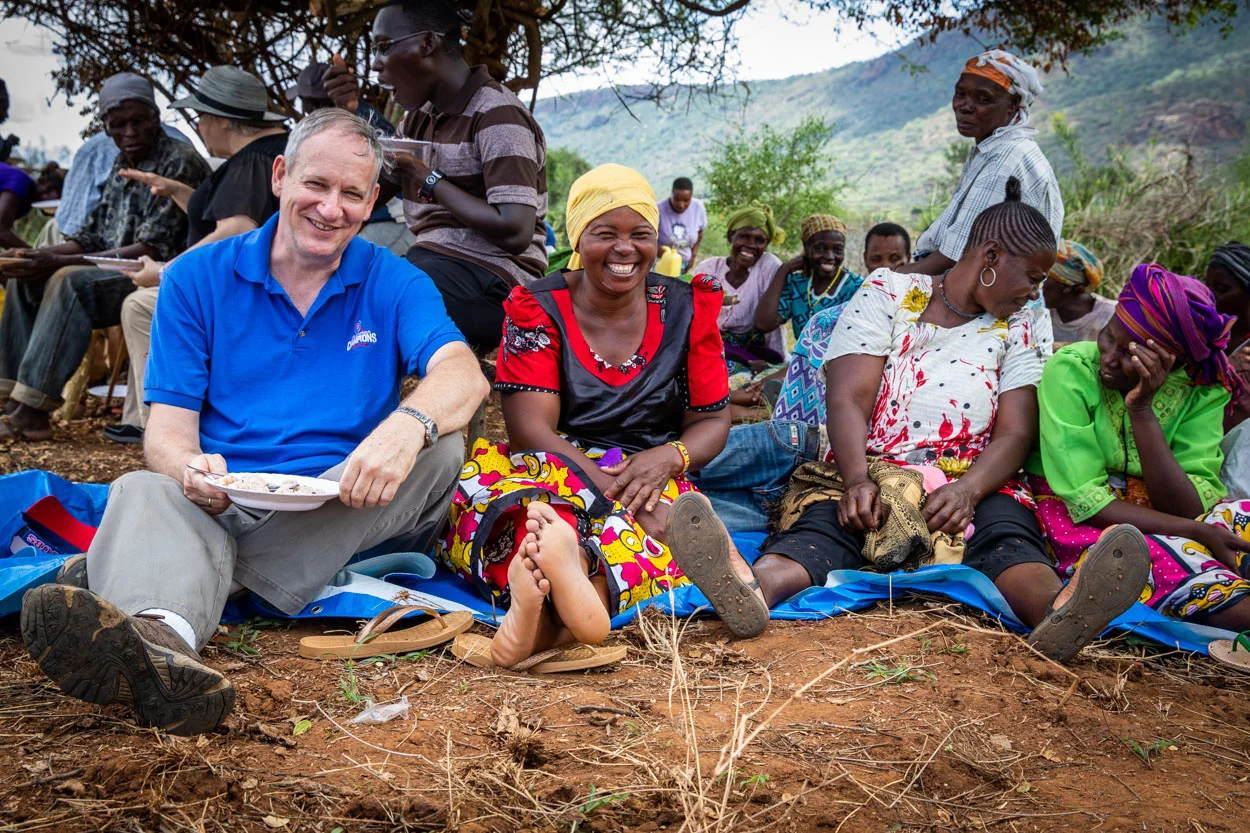 Maryknoll representative eating with village women