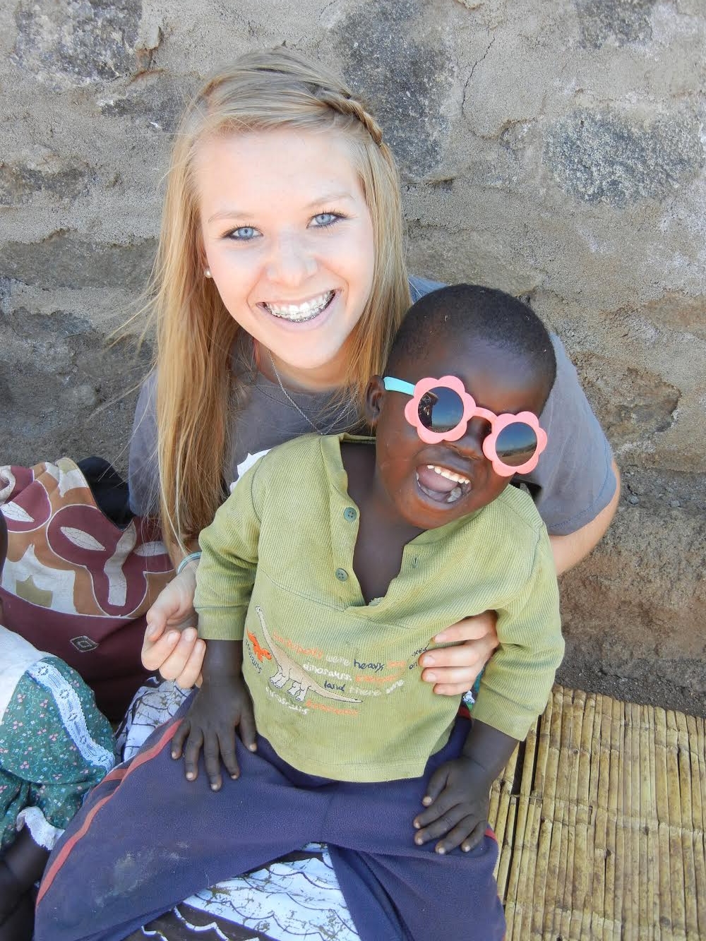 Mickenzie, summer of 2014 with Boniface outside of Patricia's Home. You would never guess by that smile that he once was a child in the background with little to no emotion. 