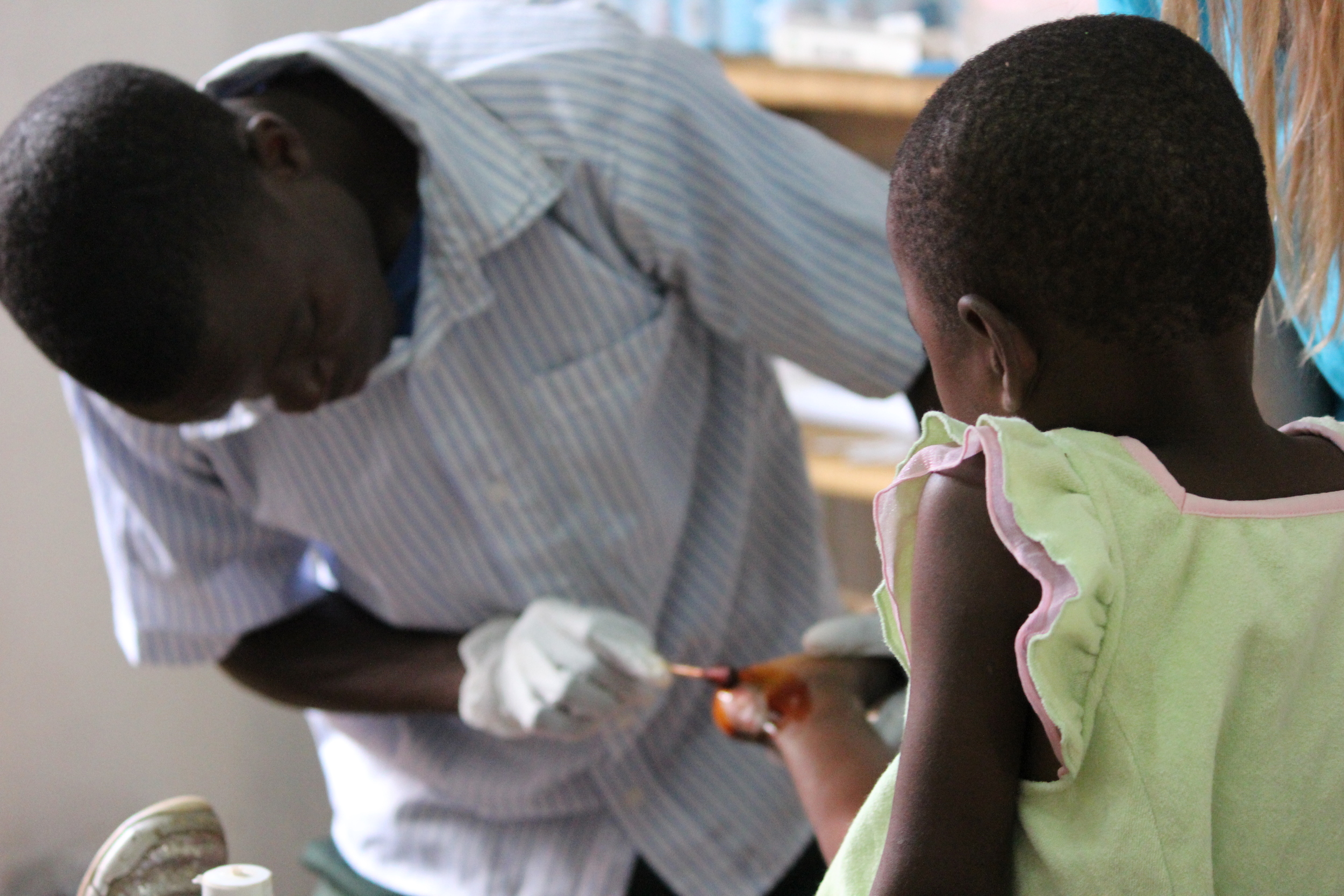 Kennedy running treating a wound, clinic summer 2014