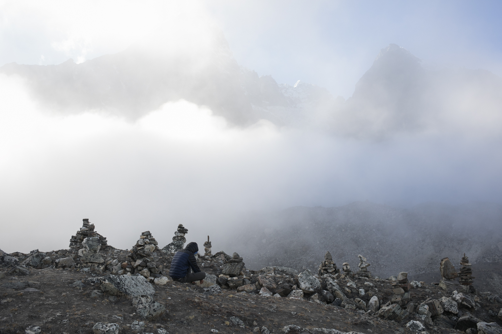 A porter tries to get cell phone reception from atop the glacial moraine. 