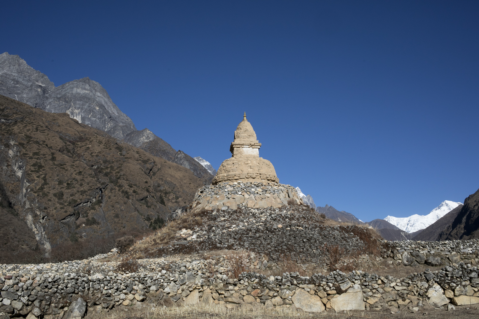 Stupa aged by the wind and winters stands at the edge of Phortse. In the background, you can see Cho Oyu, the sixth highest mountain in the world. Cho Oyu, China, 8,201 m / 26,906 ft. (Peakfinder). 