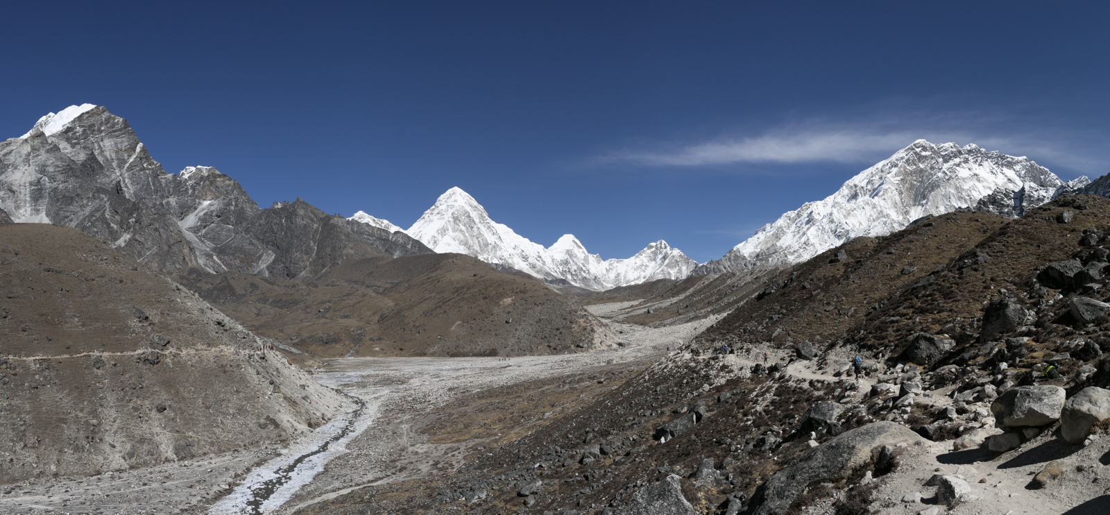 The Khumbu Glacier streches down the valley with small braided rivers flowing with silty white water. Left to Right: Chumbu 6,859 m / 22,503 ft, Pumori 7,161 m / 23,494 ft, Lingtren 7,161 m / 23,494 ft, Khumbutse 6,636 m / 21,772 ft, Nuptse 7,861 m / 25,791 ft.