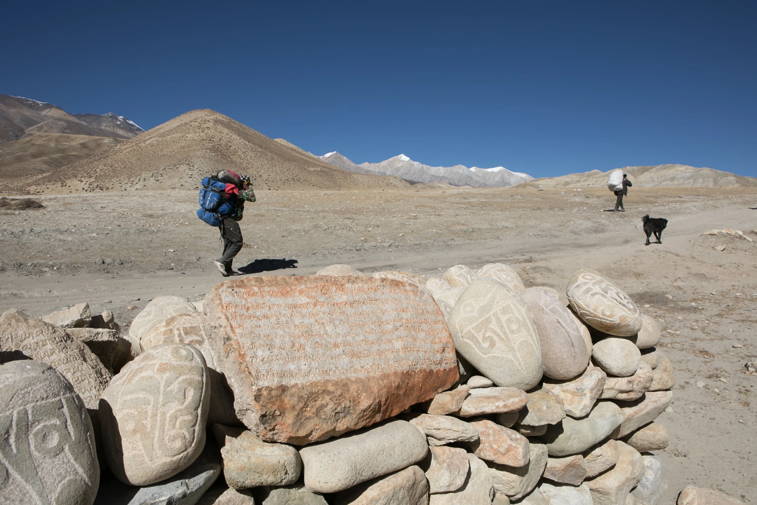 Our porter, Ram, walking near a Mani wall on the way to Lo Manthang. A black dog joined us on our entire hike, sticking close to Lo Manthang. 
