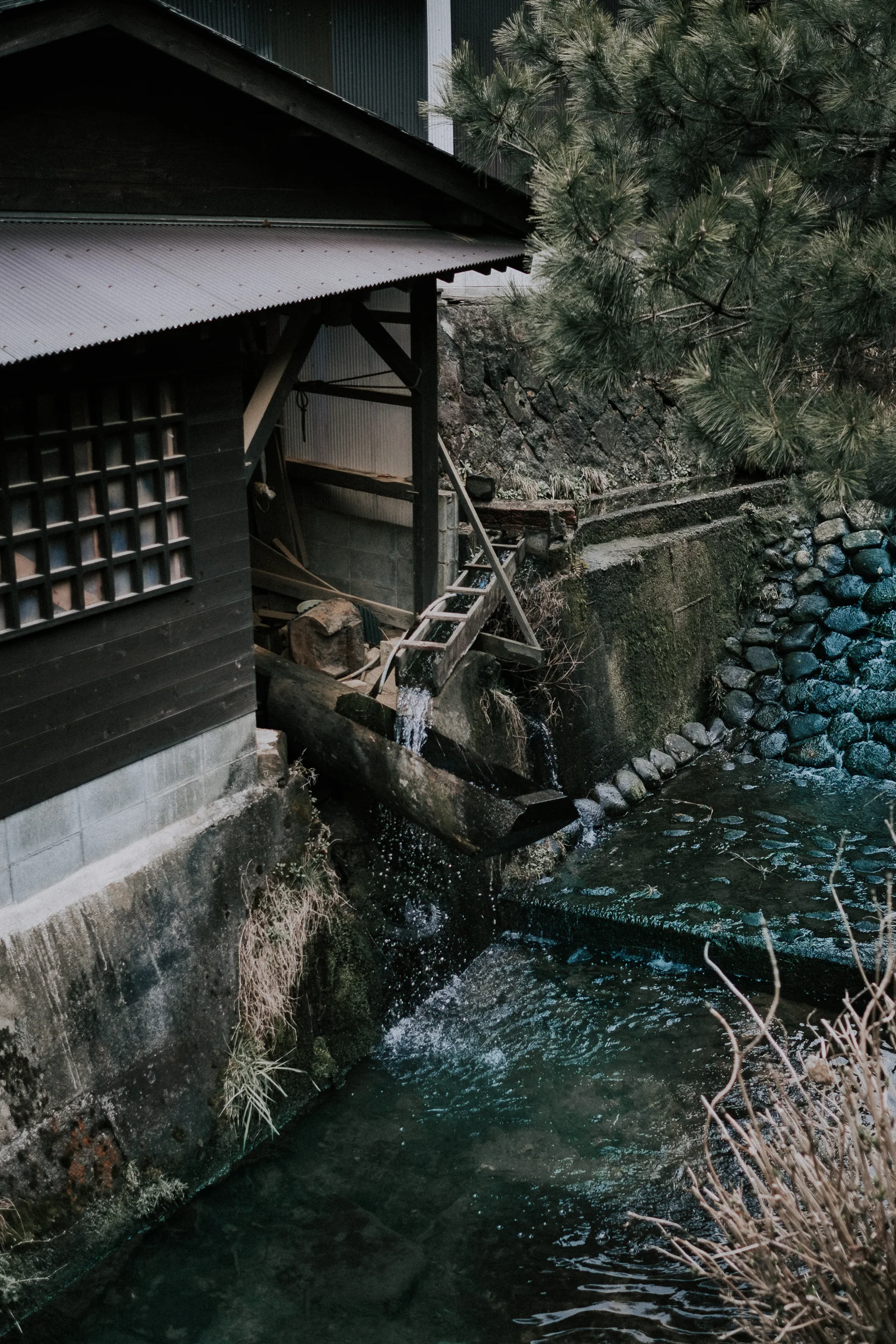 A karausu in Ontayaki no sato. As it fills with water the opposite side lifts up. When the water spills out, the other side drops and pounds the clay into powder. 