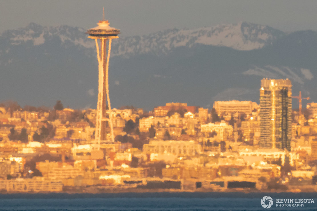 Strong heat distortion of Seattle skyline taken from over 7 miles of water. Air temperature ~ 75 °F, water temperature ~47 °F. 500 mm, 1/400 sec, f/9, ISO 1250.