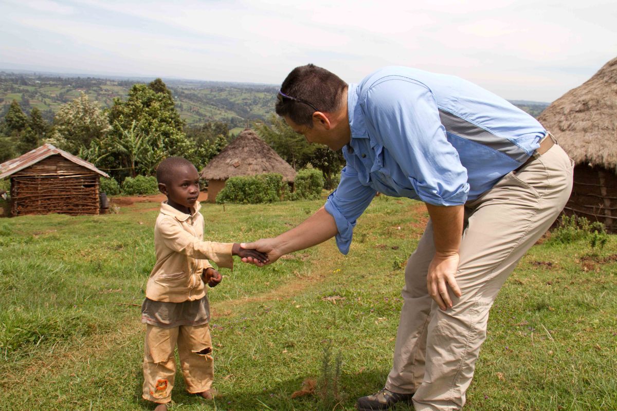 Keith Forwith shaking hands with Kenyan child