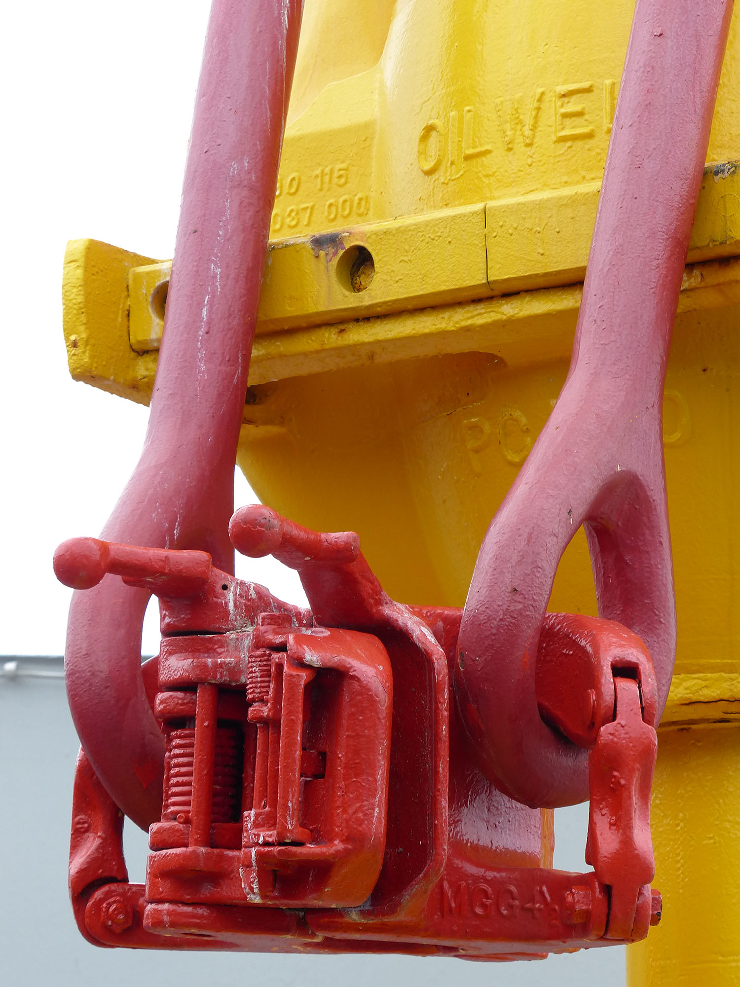 The big clamps that go around the pipes are called elevators. The two arms holding them up are called bails.