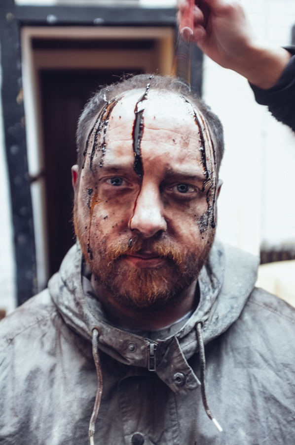 The reason why Dan looks so happy is because the makeup artist Simone has just poured hot treacle over his head!