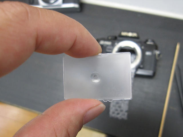 Focusing screens are relatively easy to swap in and out yourself without specialist knowledge or tools being required. The downside is that they can reduce a lot of light from entering into the viewfinder due to the ground glass they are made of like the one seen above. Image courtesy of Matthew (mattdm) Miller