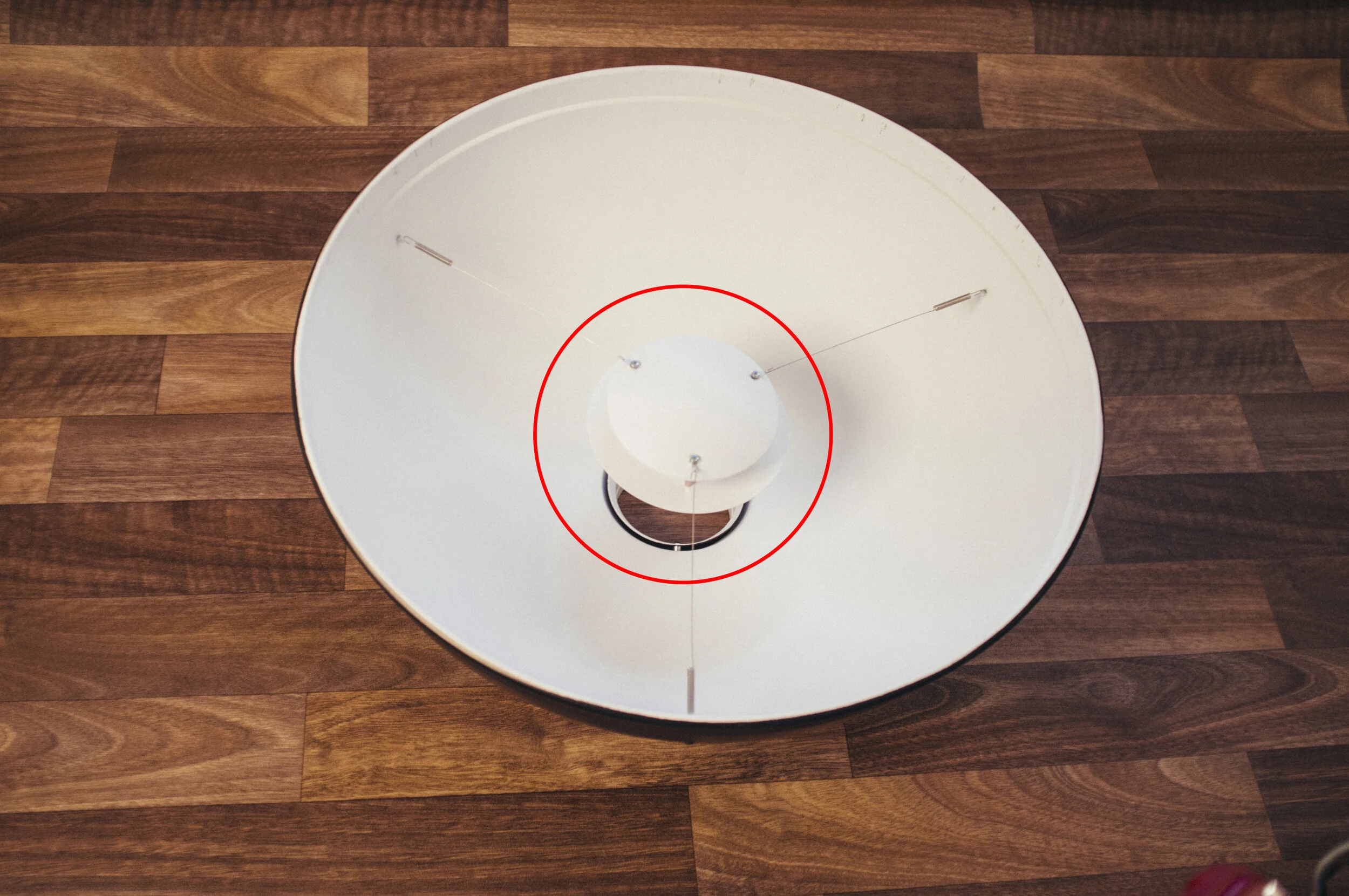 The diffusion cone/dish you see here is situated above the hole the flash fires through. This results in the light being far more evenly spread around the modifier with very minimal hot-spot as a result.