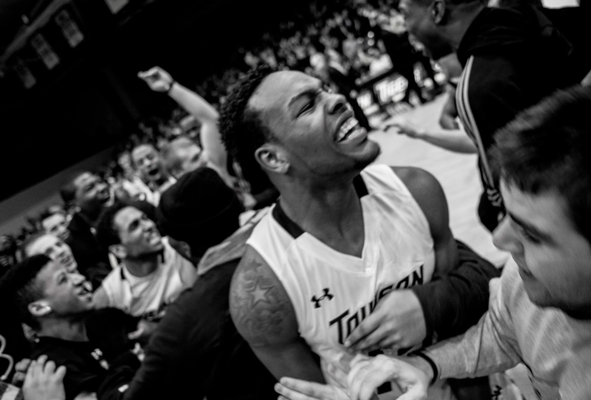 Towson University men's basketball forward Timajh Parker-Rivera celebrates with fans as they rush the court after their record breaking win over Hofstra University on March 2, 2013 in Baltimore, Md.