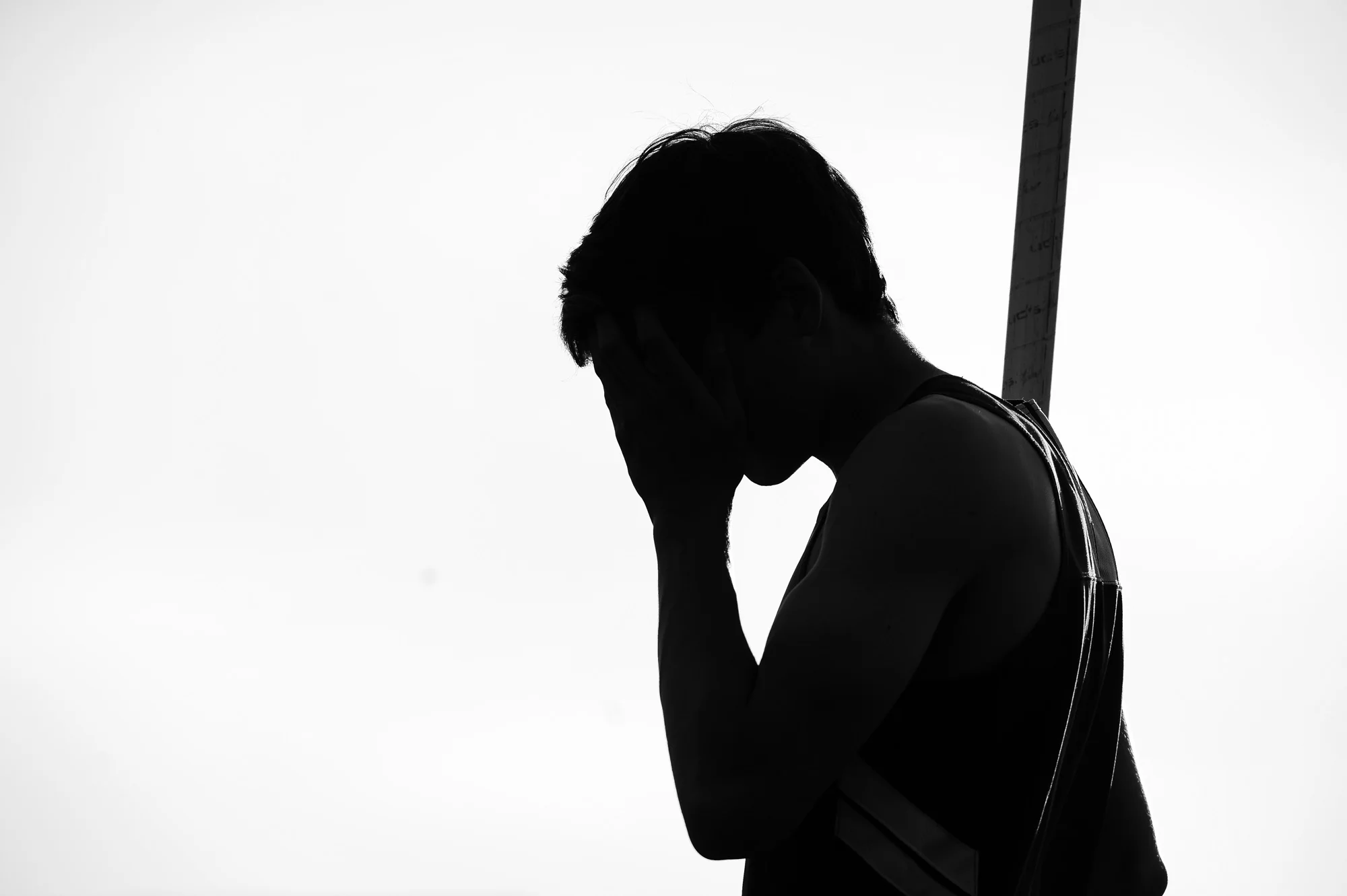 Calvin Pitney of Glenelg High School wipes sweat from his face before competing in the pole vault competition on the second day of the Howard County Track Championships at Wilde Lake High School in Columbia, Maryland on May 6, 2014.
