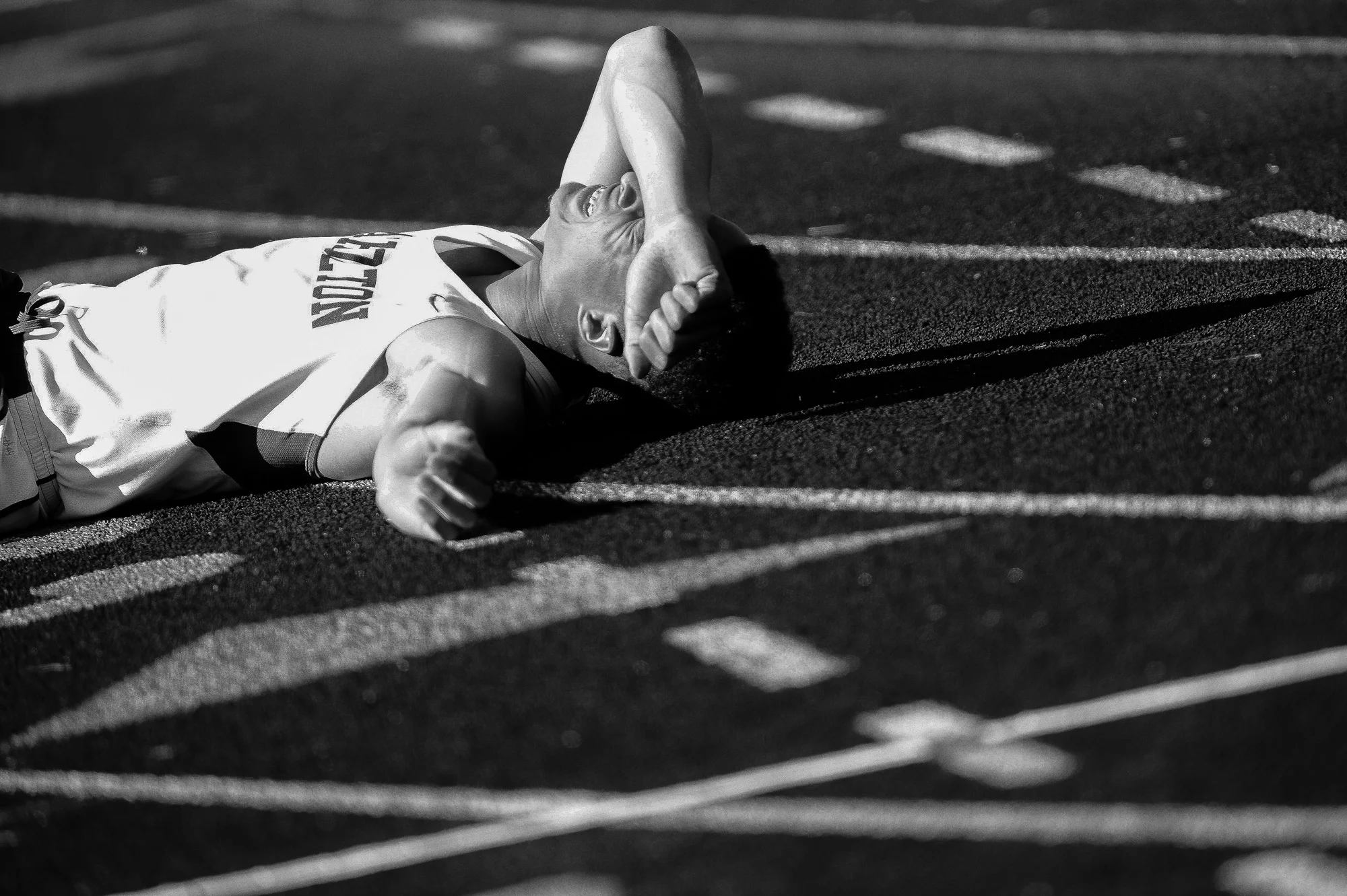 Miles Walker of Atholton High School rests on the track after the boy's 400 meter dash on the second day of the Howard County Track Championships at Wilde Lake High School in Columbia, Maryland on May 6, 2014.