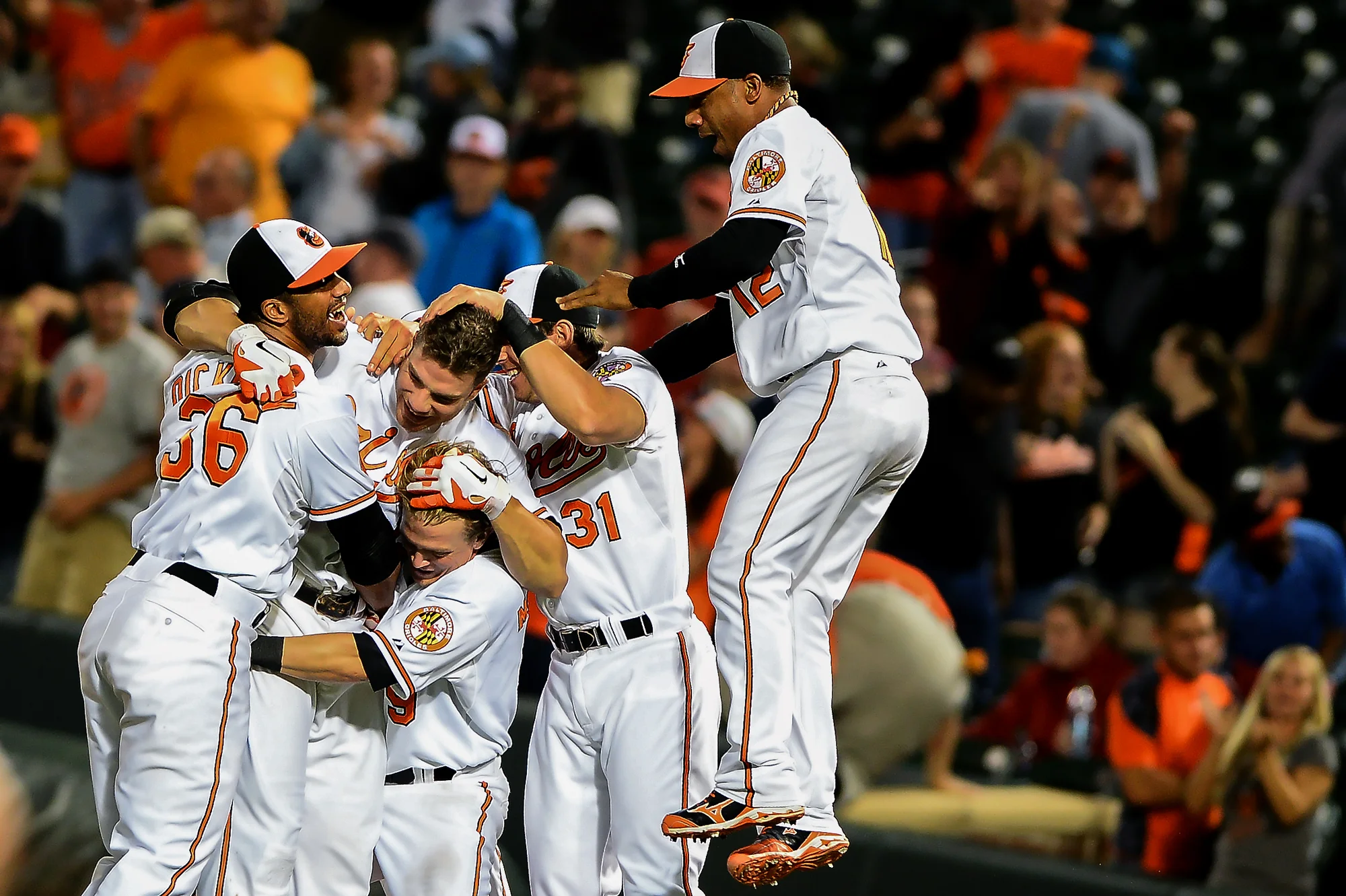 Chris Davis of the Baltimore Orioles is mobbed by his teammates after hitting the game winning RBI in the 13th inning against the Boston Red Sox at Oriole Park at Camden Yards on June 13, 2013 in Baltimore, Md.