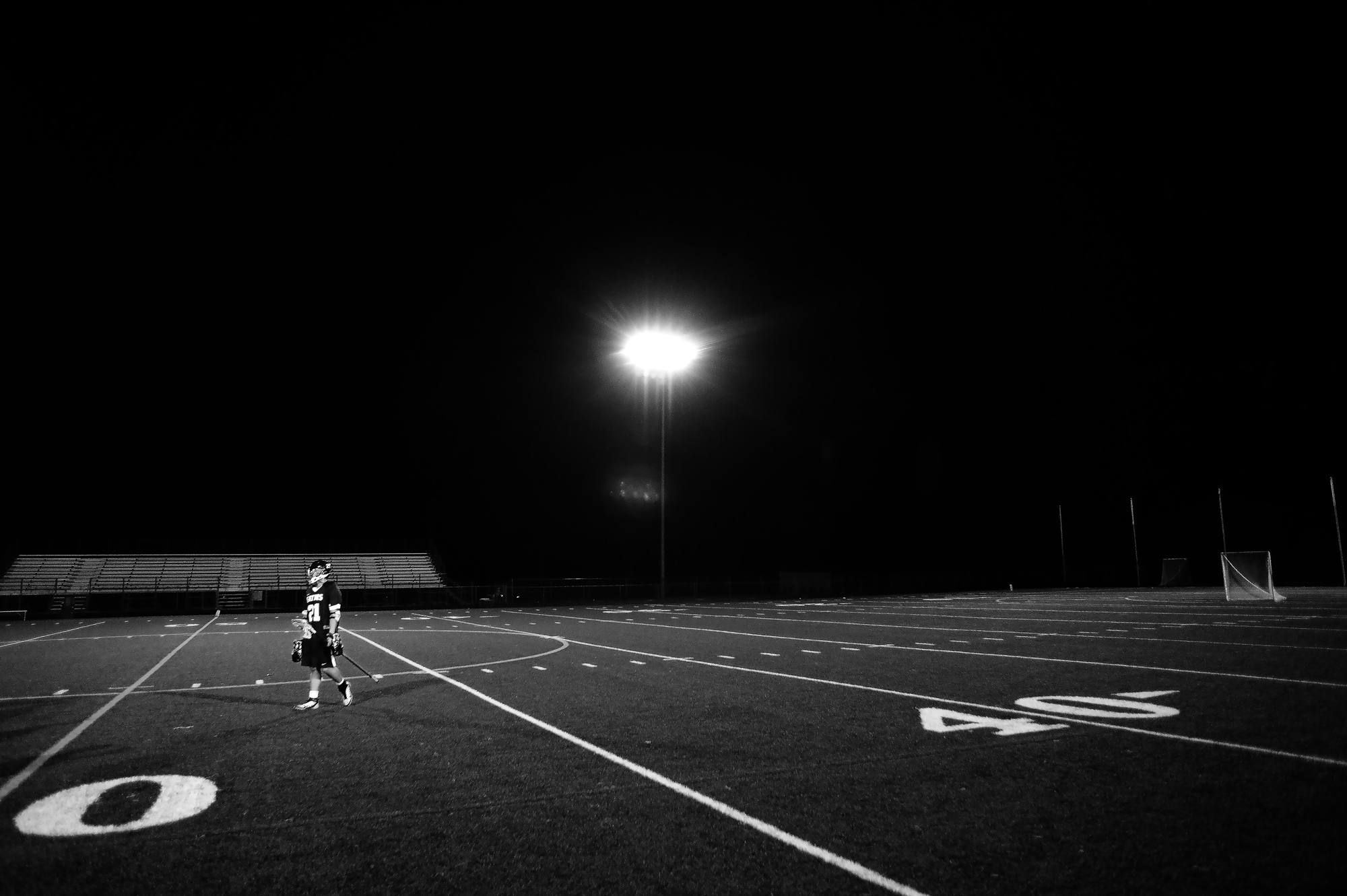 Jonathan Koh of Reservoir High School walks off the field after losing to Howard High School in a boy's lacrosse game in Columbia, Maryland on March 28, 2014.