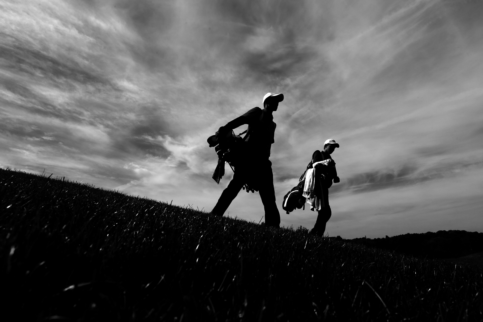 Young Lee, left, of Glenelg High School and Jackson Courtney of Marriotts Ridge High School walk off of the green of hole 9 during the District V golf tournament in Columbia on October 20, 2014.