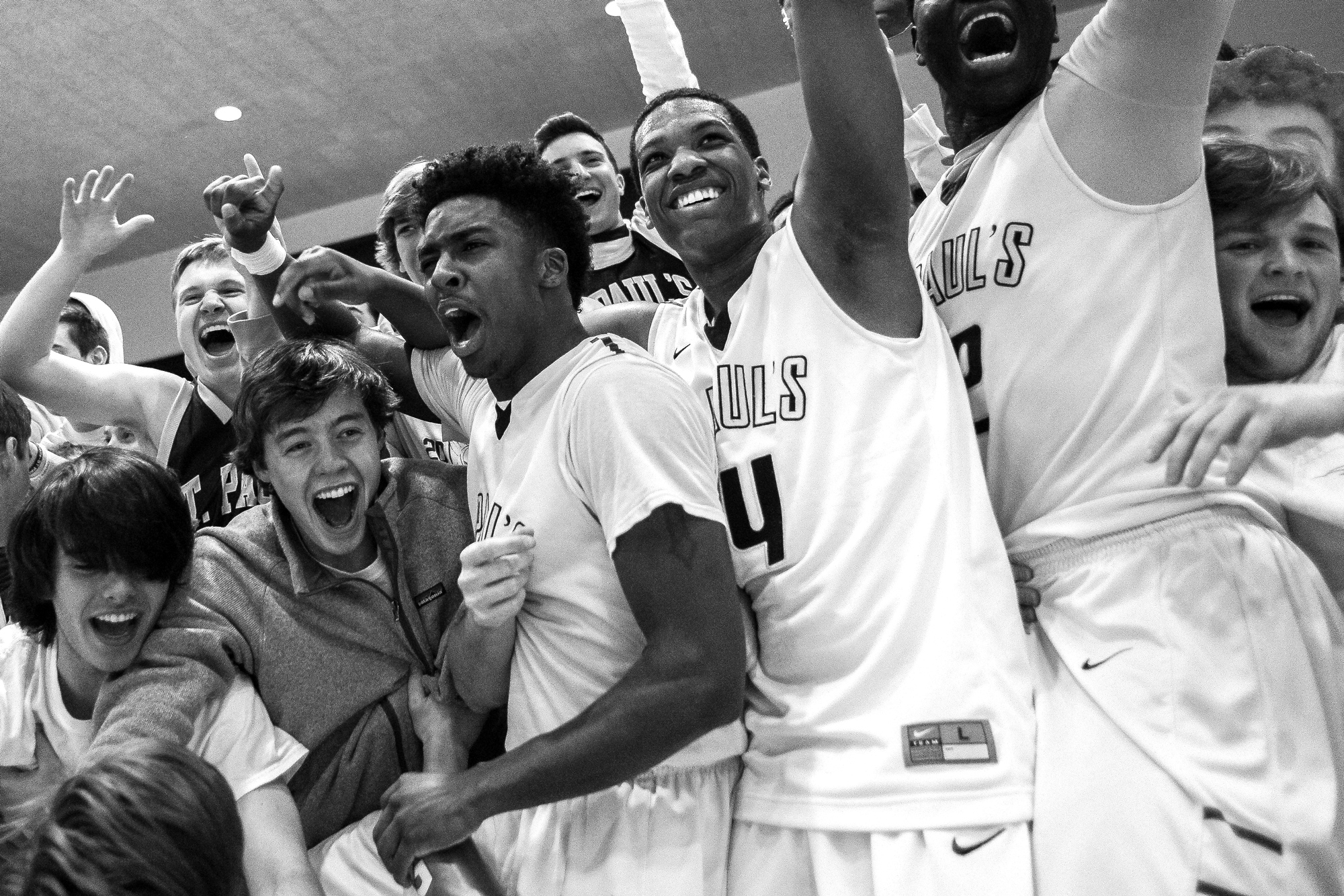 St. Pauls High School players (from left to right) Tre Hamer, Ryan Lee, and Iba Camara collide with fellow students after winning the MIAA B Conference Championship at UMBC RAC on Feb. 16, 2014.