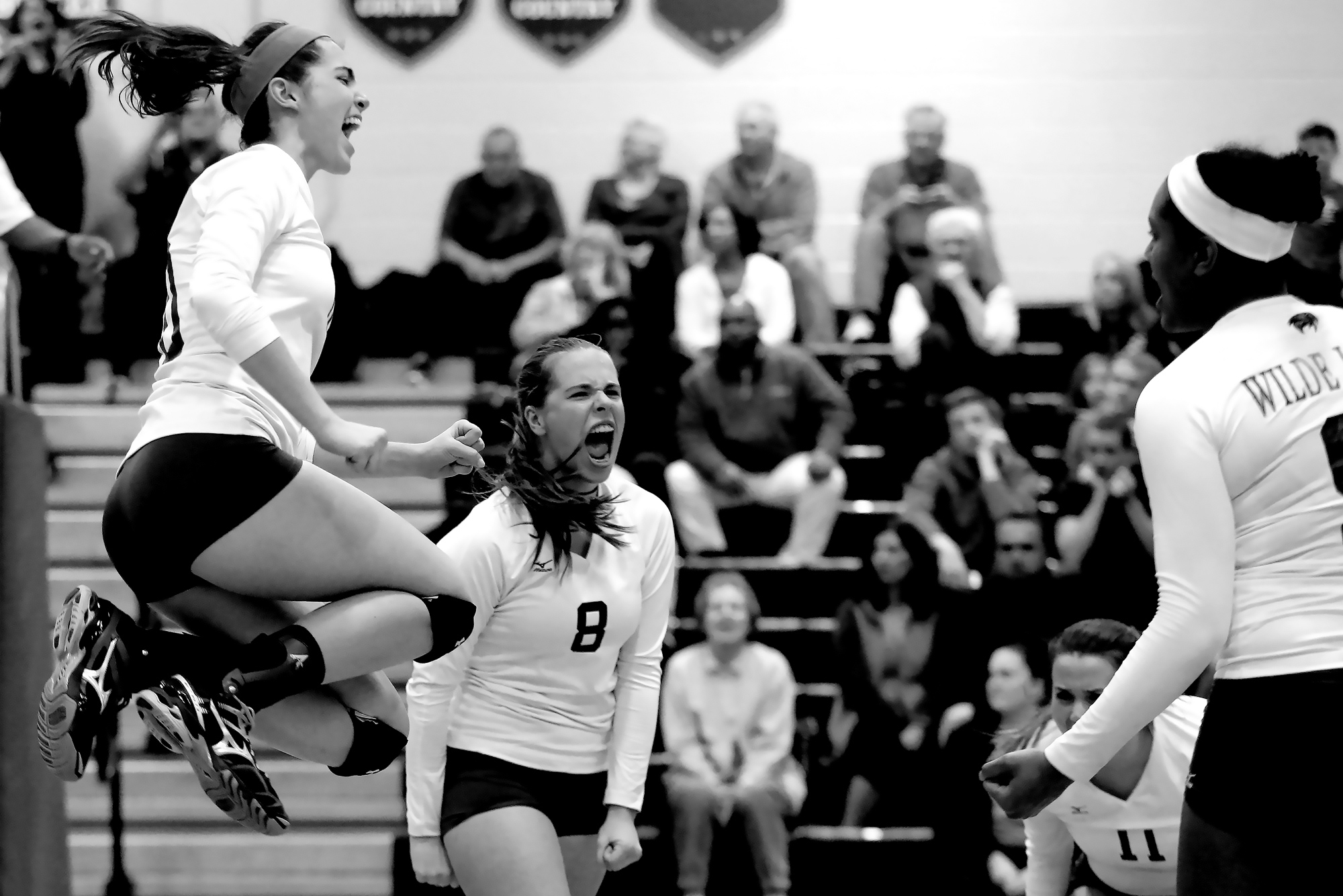 Camille Johnson, left, and Faith Leslie of Wilde Lake celebrate after defeating Reservoir during a regional playoff volleyball game in Columbia, Maryland on November 3, 2014. 