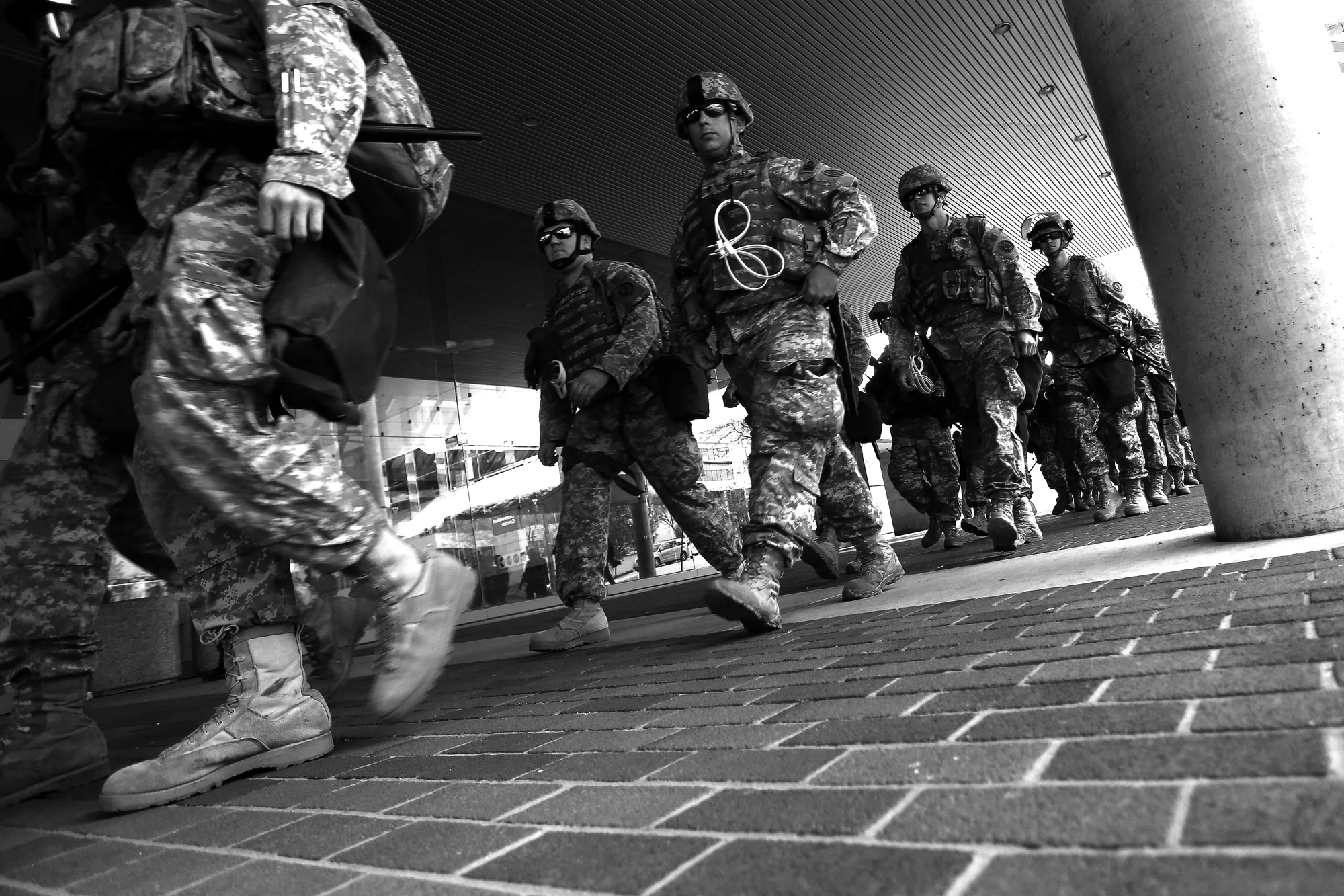 Members of the National Guard walk in front of the Baltimore Convention Center while protestors march after the announcement that all six officers will be charged following the death of Freddie Gray while he was in police custody, May 1, 2015 in Baltimore, Maryland.