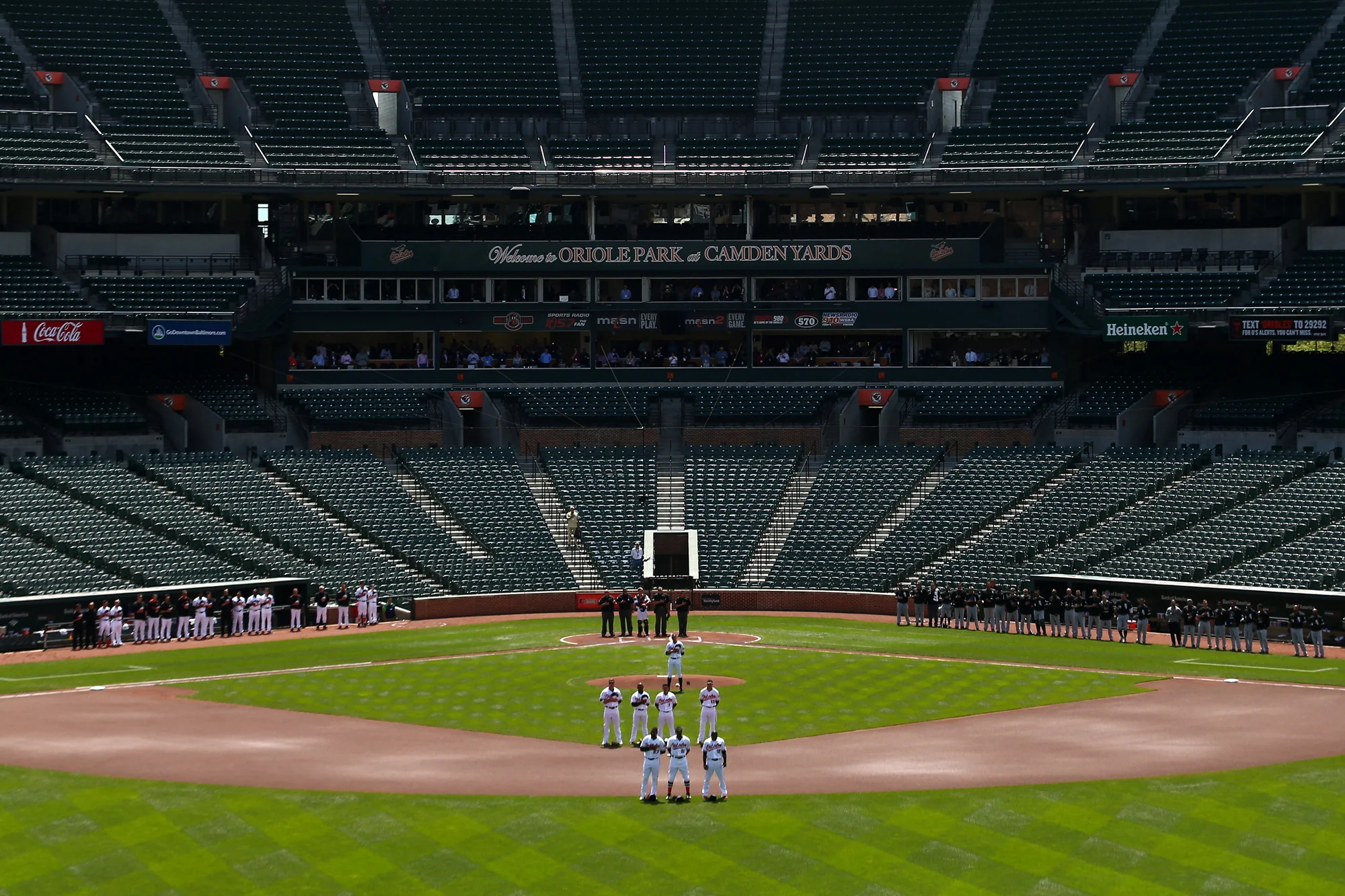 The Baltimore Orioles and Chicago White Sox stand for the nation anthem at an empty Oriole Park at Camden Yards on April 29, 2015 in Baltimore, Maryland.