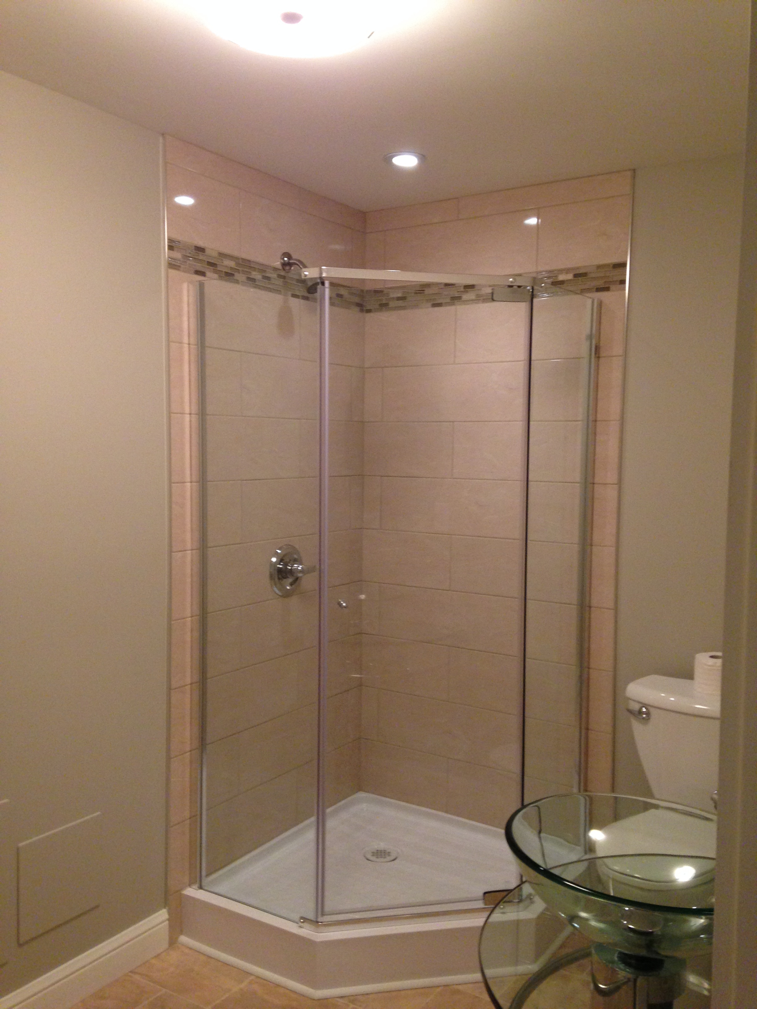 Custom tiled shower with acrylic base and glass doors