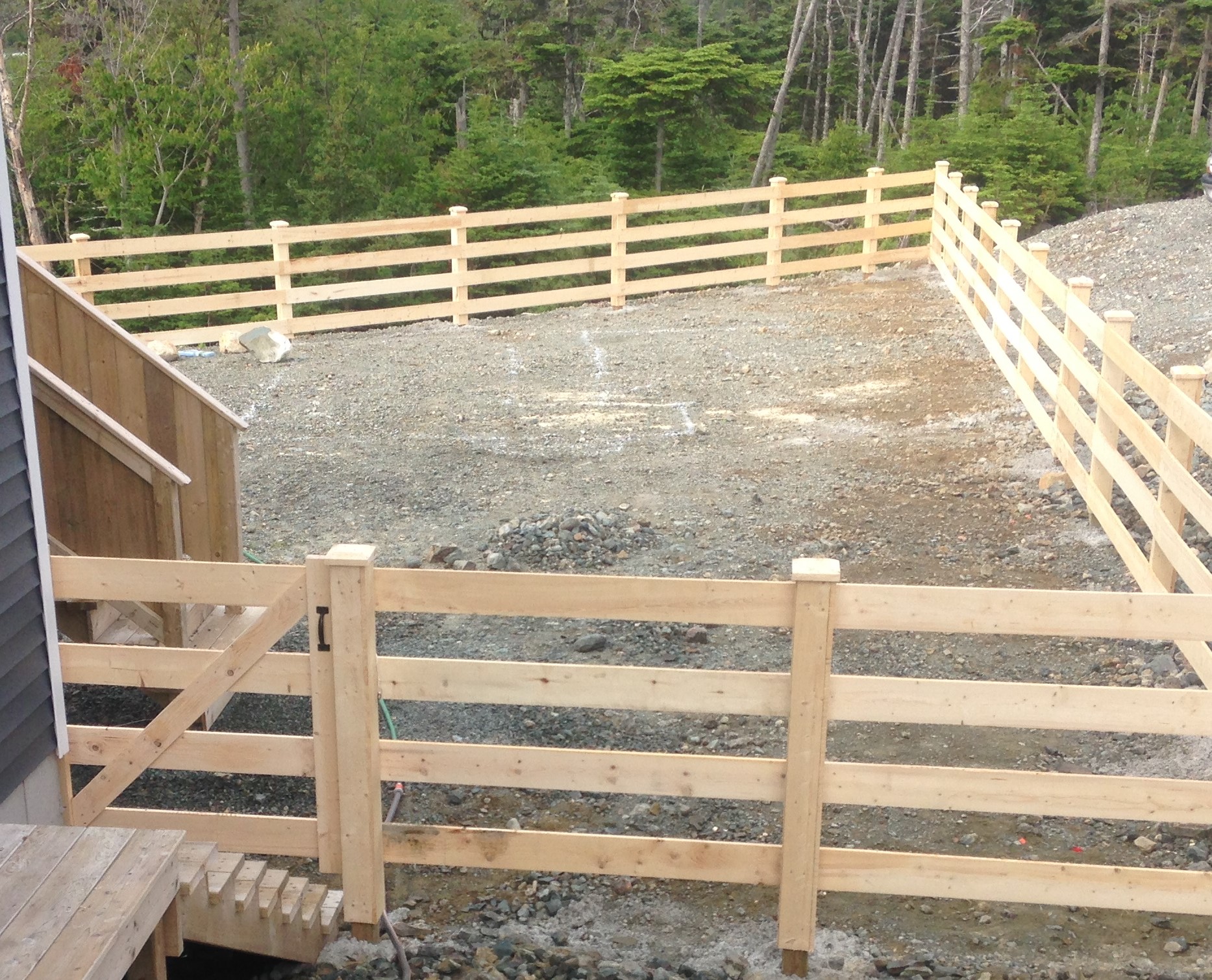 Pressure treated posts in concrete, clad with rough cut lumber and rough cut rails