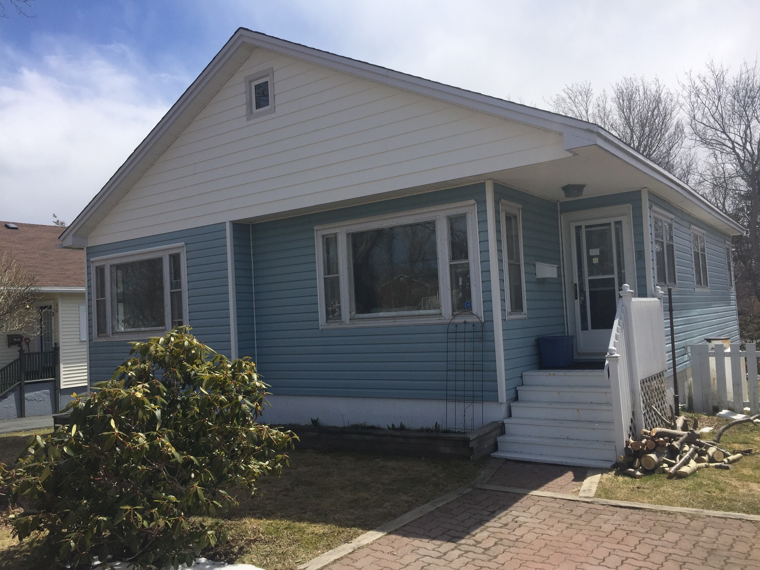 Before - Vinyl and wood siding with old wooden frame storm windows.