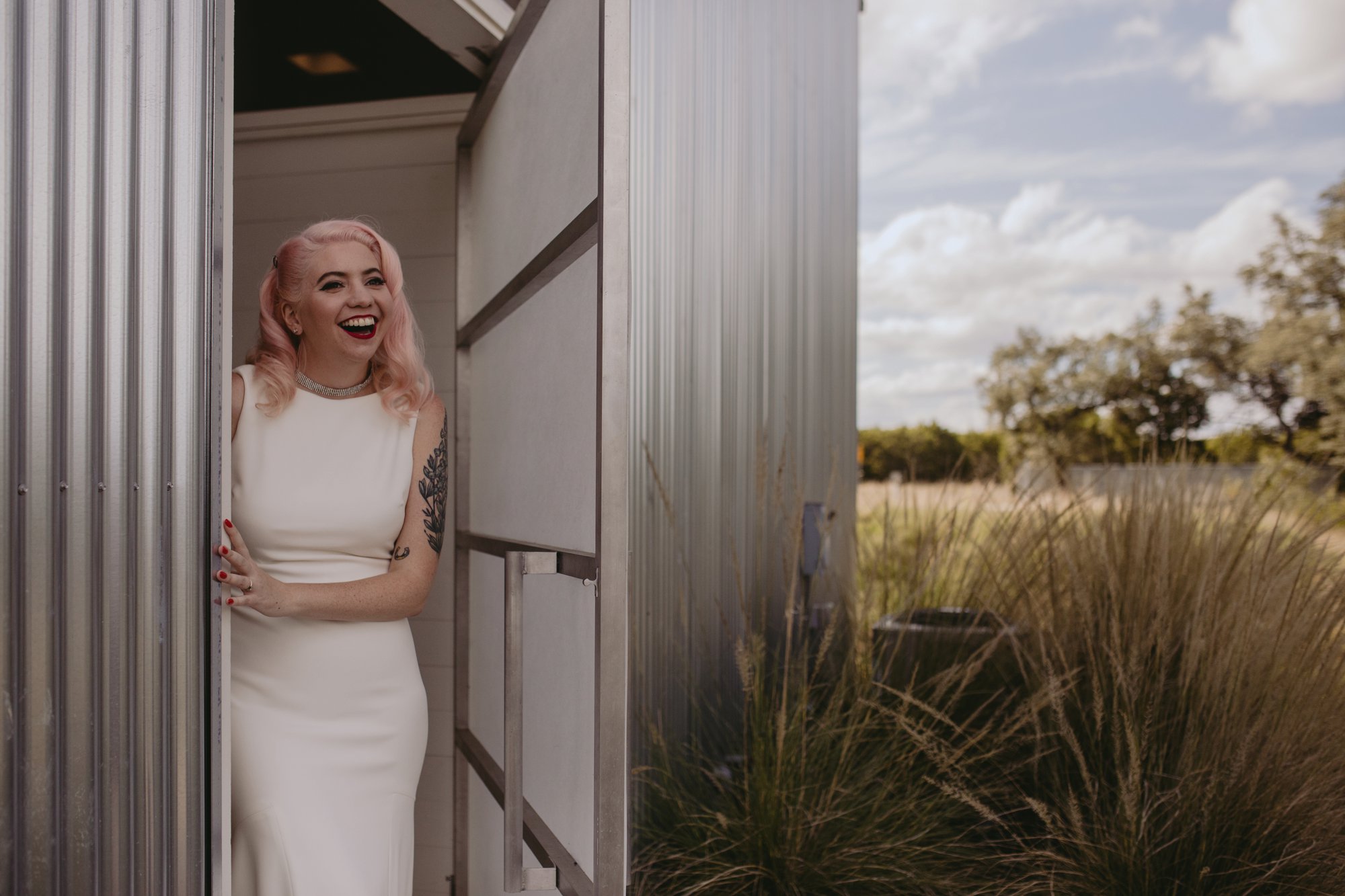 Bride with pink hair and groom in a purple suit prospect house wedding in austin tx with pastel decor and wild florals bride first look