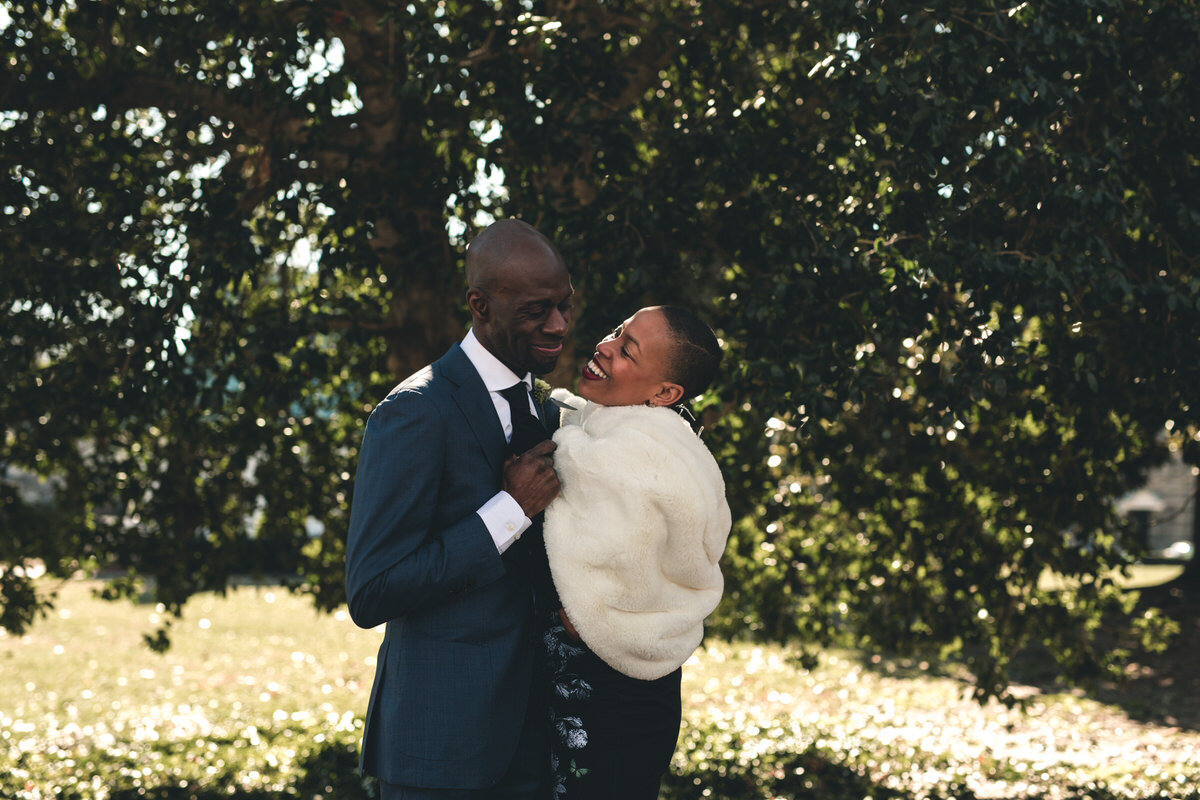  Newlyweds embracing outside under a tree at the Museum of Fine Arts in Richmond, VA, photo by Carly Romeo 