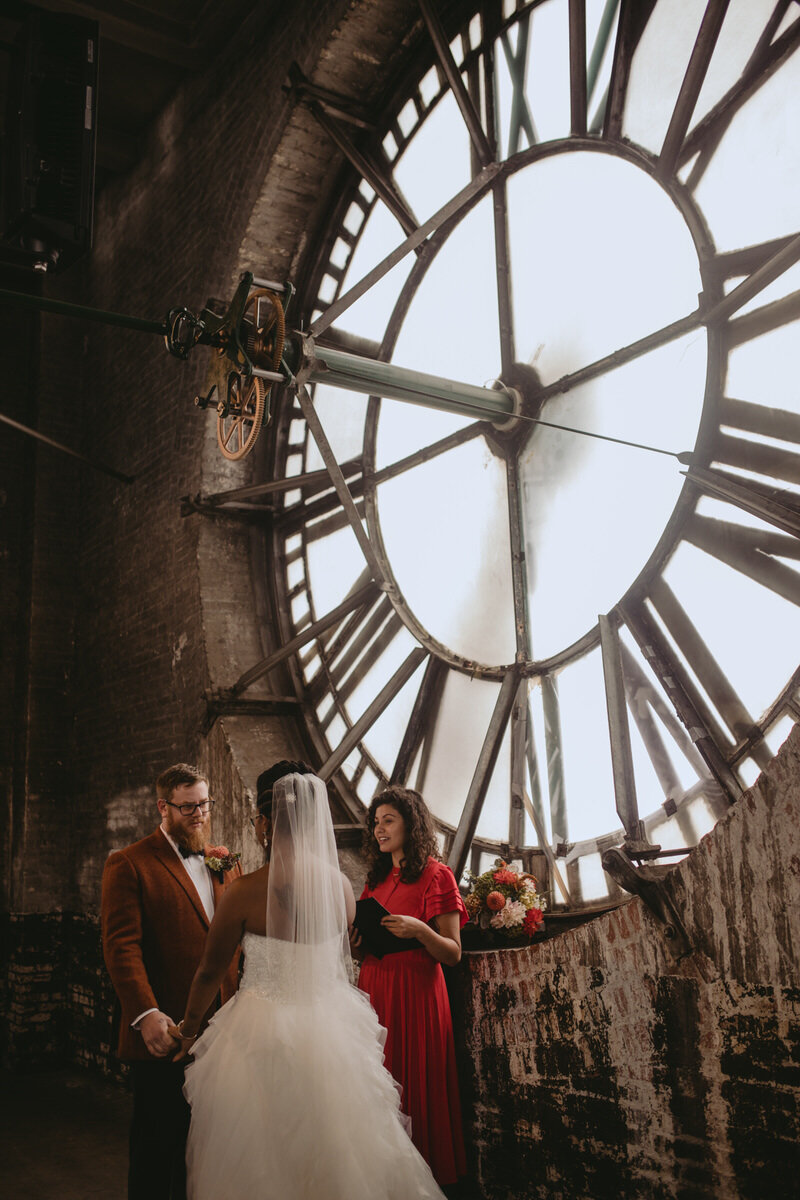 Multicultural couple with officiant getting married at The Bromo Arts Tower in Baltimore Carly Romeo