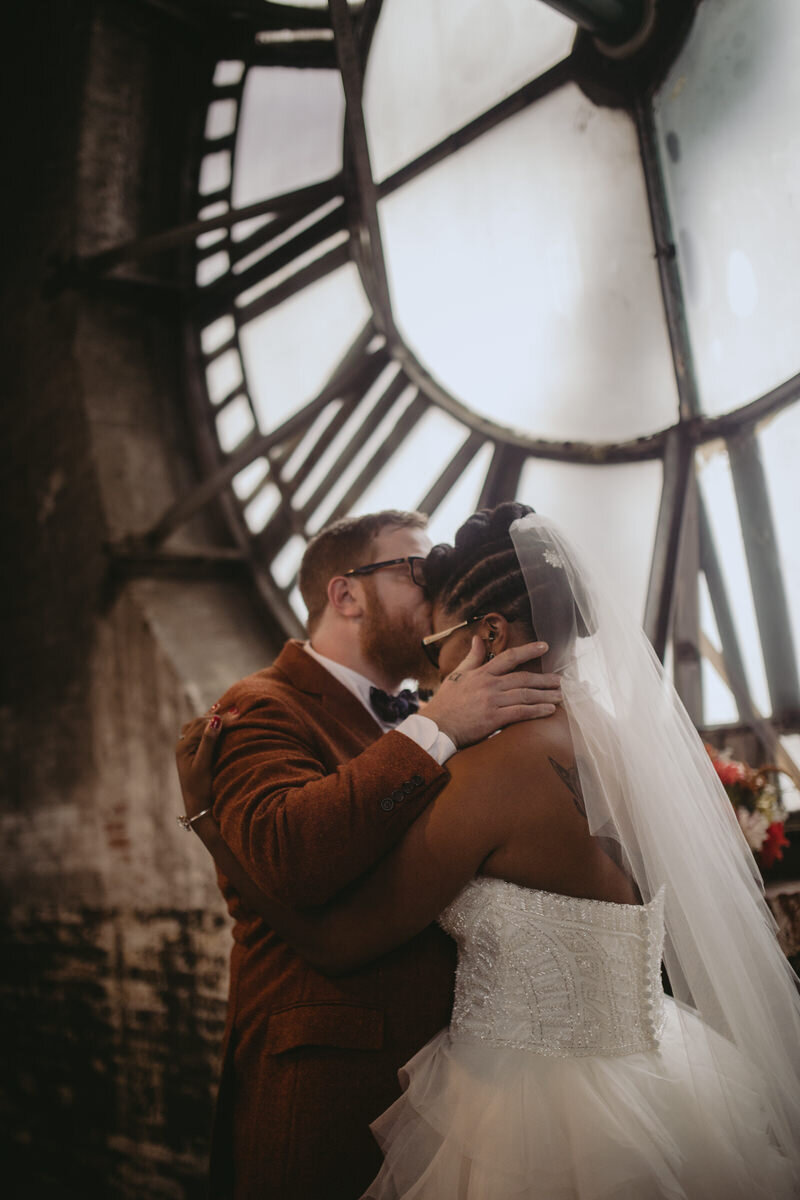 Groom kissing bride's forehead at clocktower wedding ceremony Baltimore MD Carly Romeo