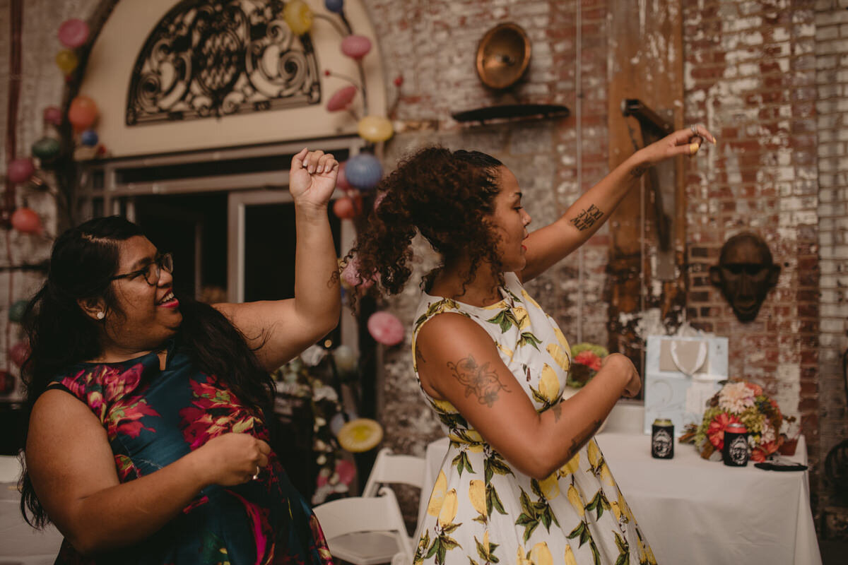 Friends dancing at wedding reception in the Corradetti Glassblowing Studio Baltimore MD Carly Romeo