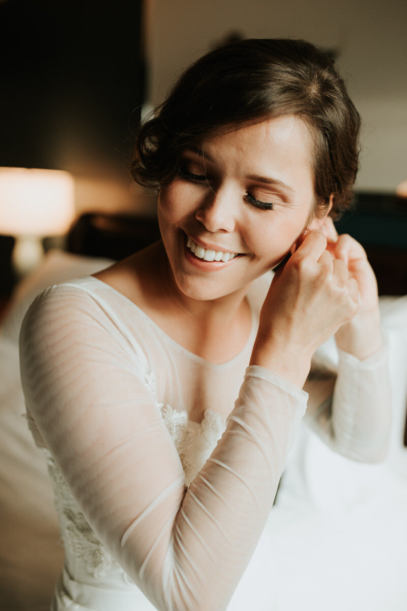 Bride putting on earrings in Richmond Virginia Carly Romeo Photography