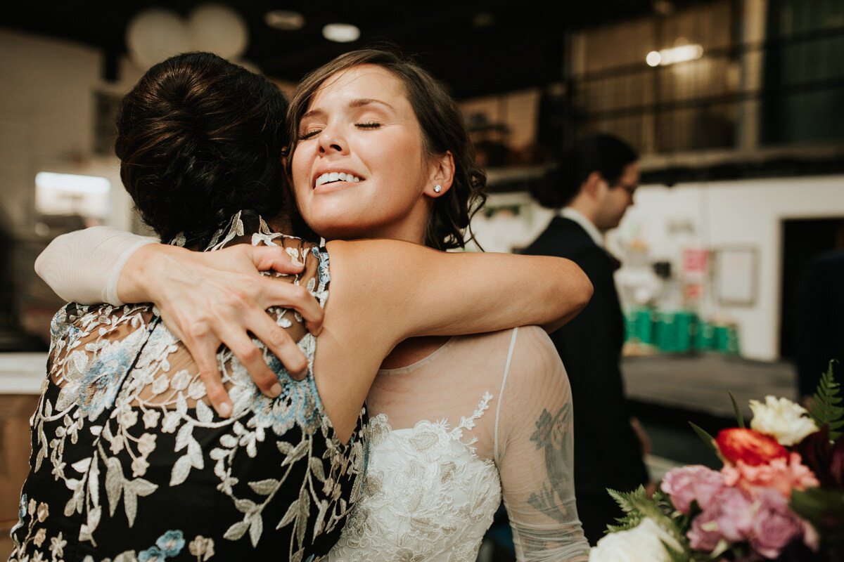 Bride hugging friend after wedding at Studio Two Three Carly Romeo Richmond wedding photography