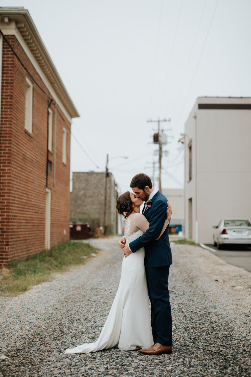 Newlywed couple kissing outside Studio Two Three in Scotts Addition RVA Carly Romeo &amp; Co.