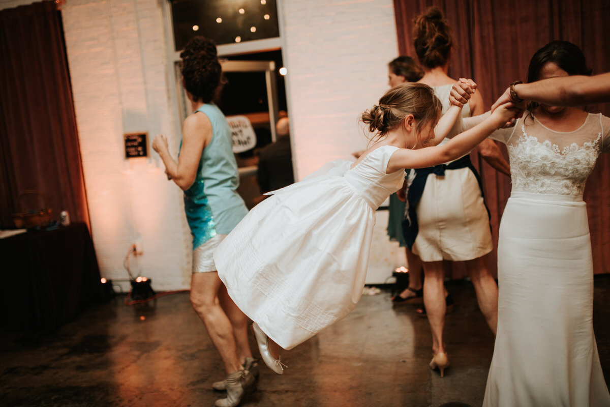 Flower swinging by arms on dance floor at wedding reception in Scotts Addition Studio Two Three RVA Carly Romeo