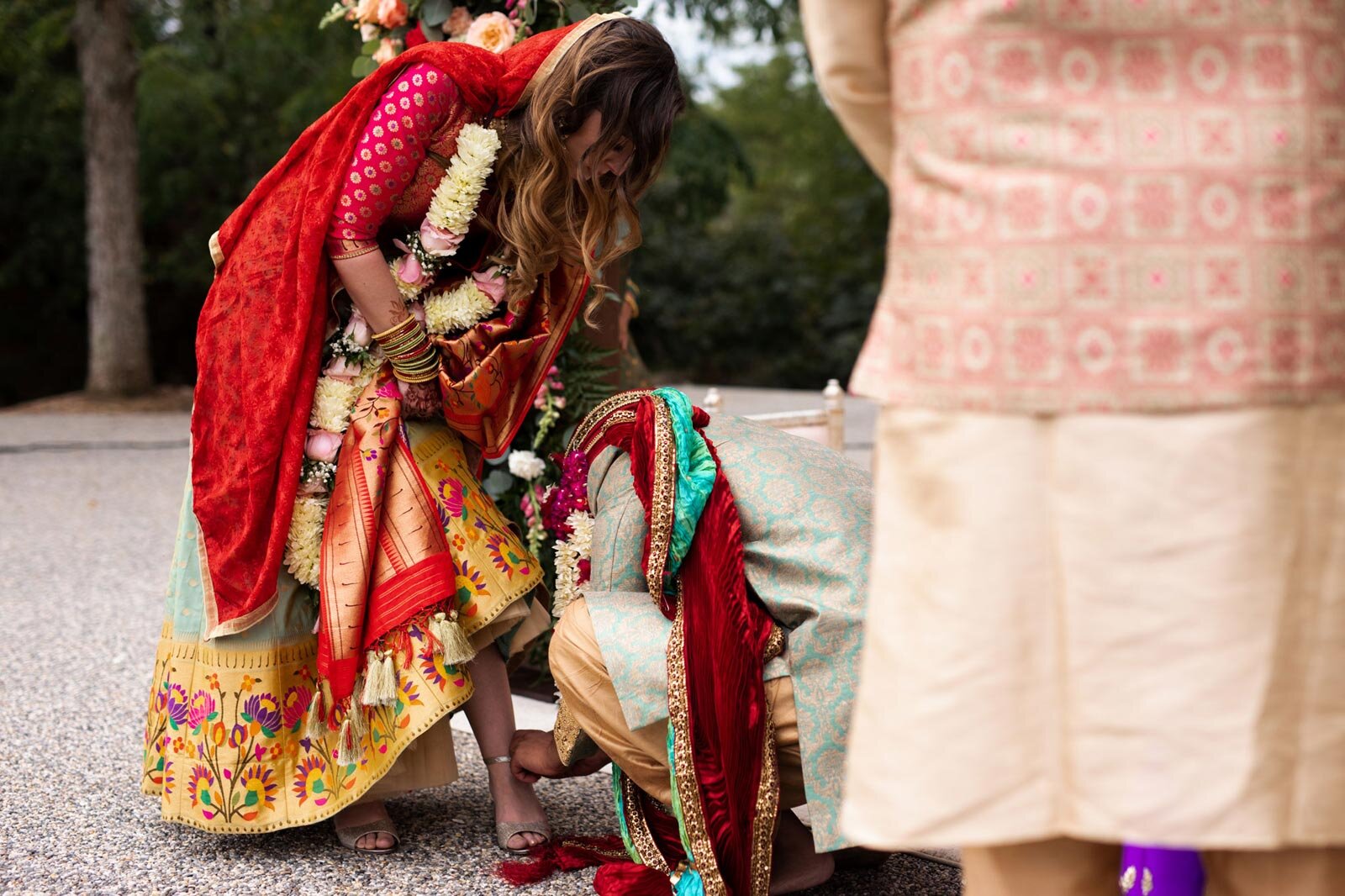 Indian groom taking off brides shoe at traditional indian wedding ceremony at Dover Hall RVA Carly Romeo &amp; Co.