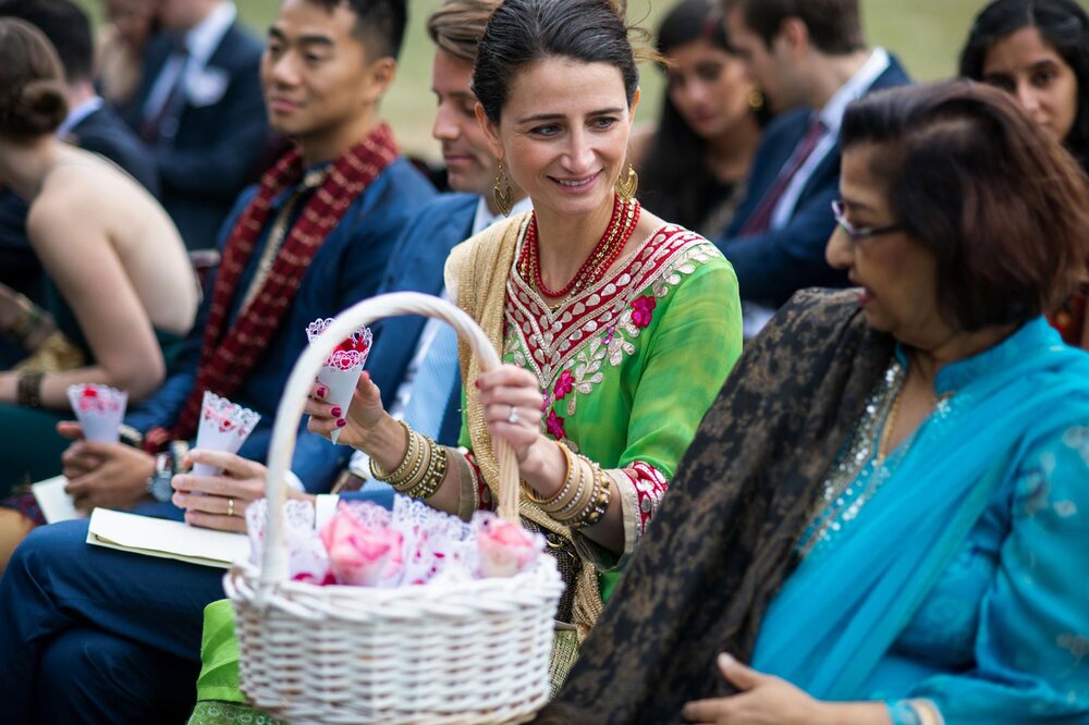 Guest passing cones of flower petals at Indian wedding at Dover Hall Richmond VA Carly Romeo + Co