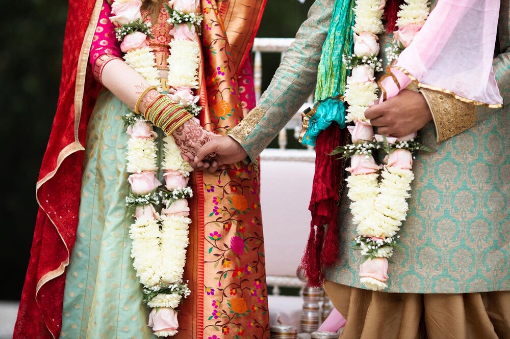 Bride and groom holding hands in traditional indian wedding dress at Dover Hall Richmond VA Carly Romeo and Co