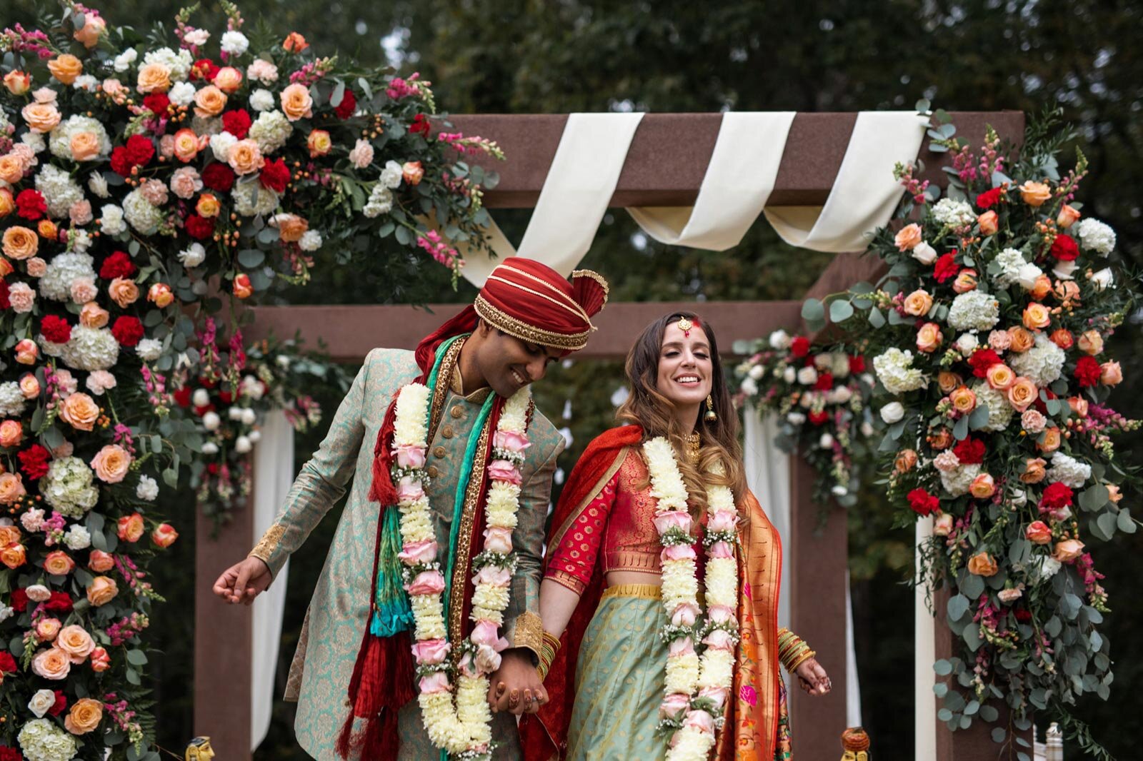 Indian groom dancing with bride under mandap at Dover Hall Richmond VA Carly Romeo wedding photography