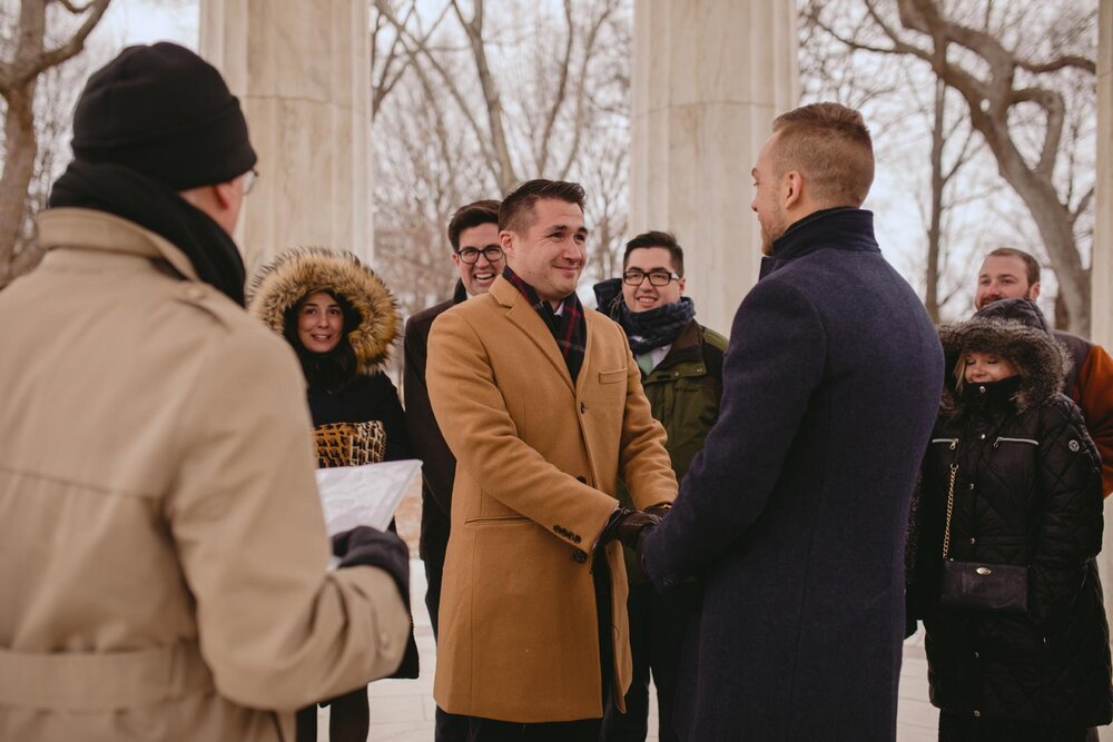 Gay couple surrounded by friends and officiant in wedding ceremony at DC War Memorial Carly Romeo and CO.