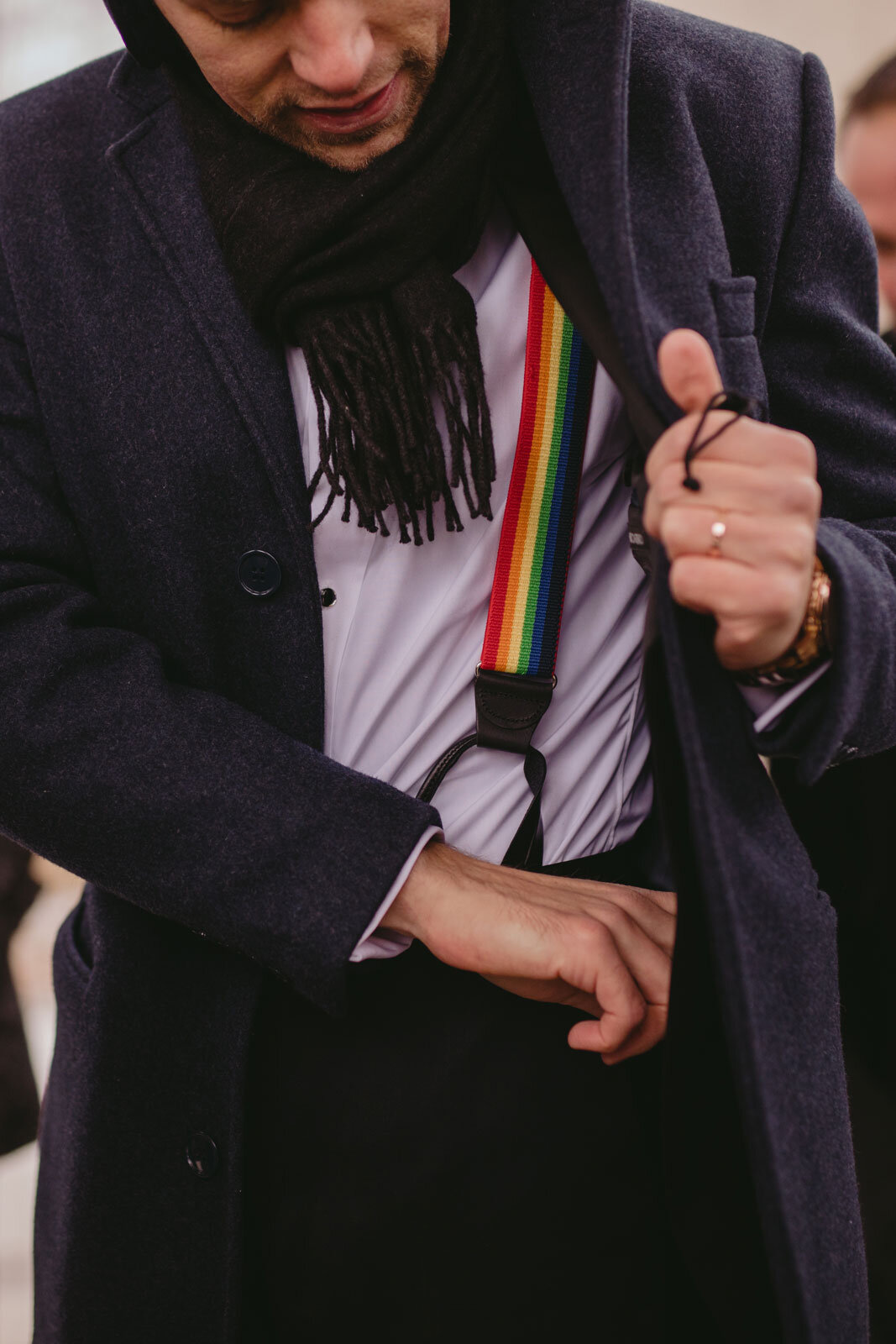 Groom reaching into jacket pocket showing rainbow suspenders in Washington DC Carly Romeo &amp; Co